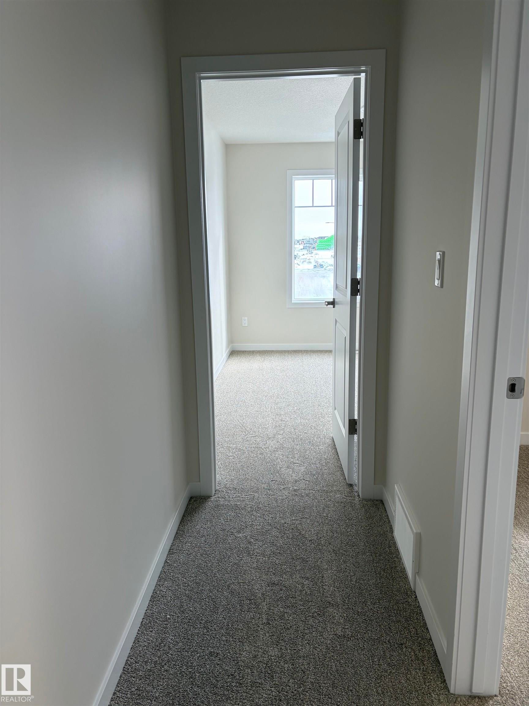 Corridor with light carpet and baseboards - 5756 Hawthorn Common, Edmonton, AB - Indoor Photo Showing Other Room