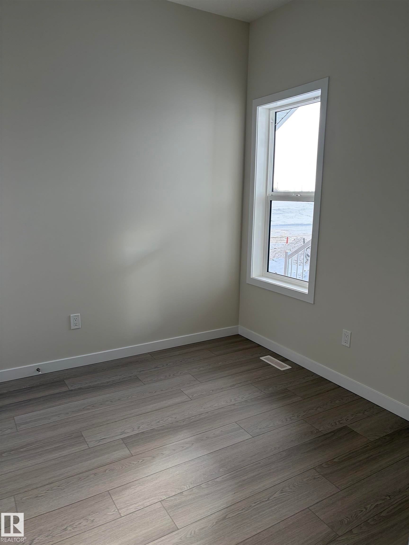 Spare room featuring baseboards and light wood-style flooring - 5756 Hawthorn Common, Edmonton, AB - Indoor Photo Showing Other Room