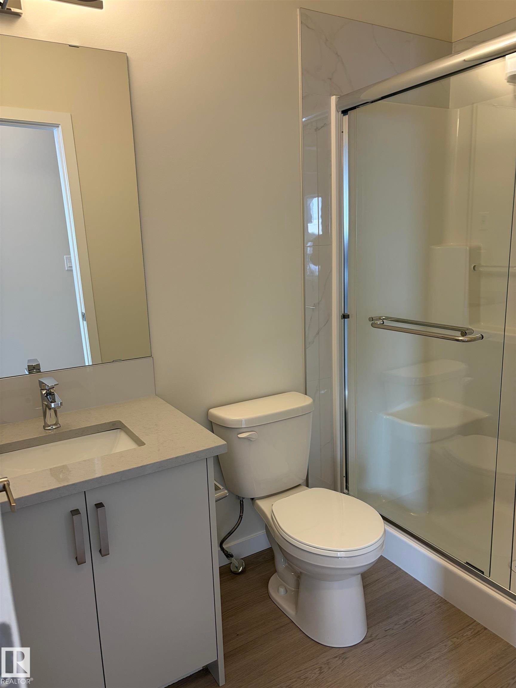 Bathroom featuring vanity, a shower stall, and wood finished floors - 5756 Hawthorn Common, Edmonton, AB - Indoor Photo Showing Bathroom