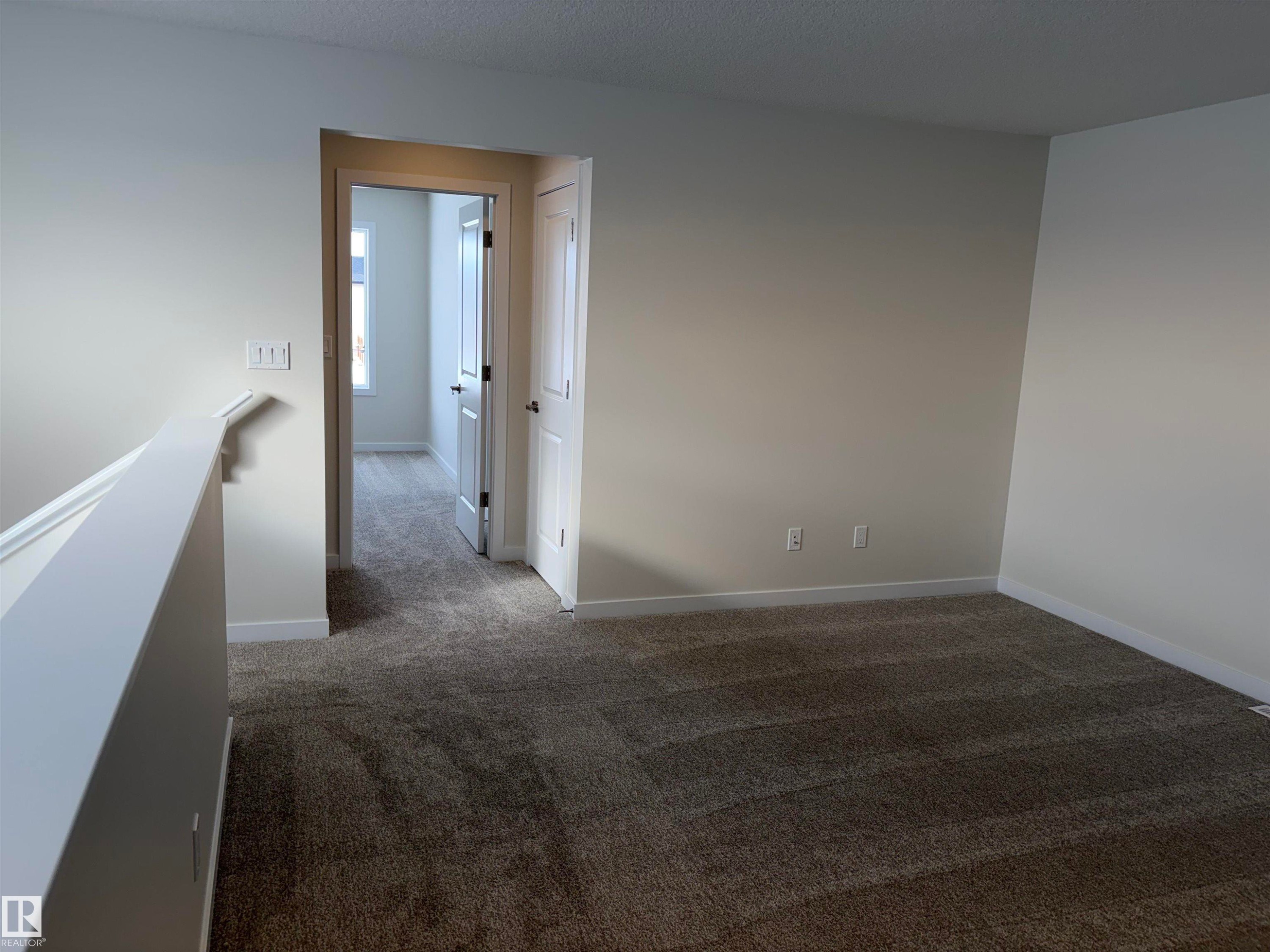 Unfurnished room with dark colored carpet and baseboards - 5756 Hawthorn Common, Edmonton, AB - Indoor Photo Showing Other Room