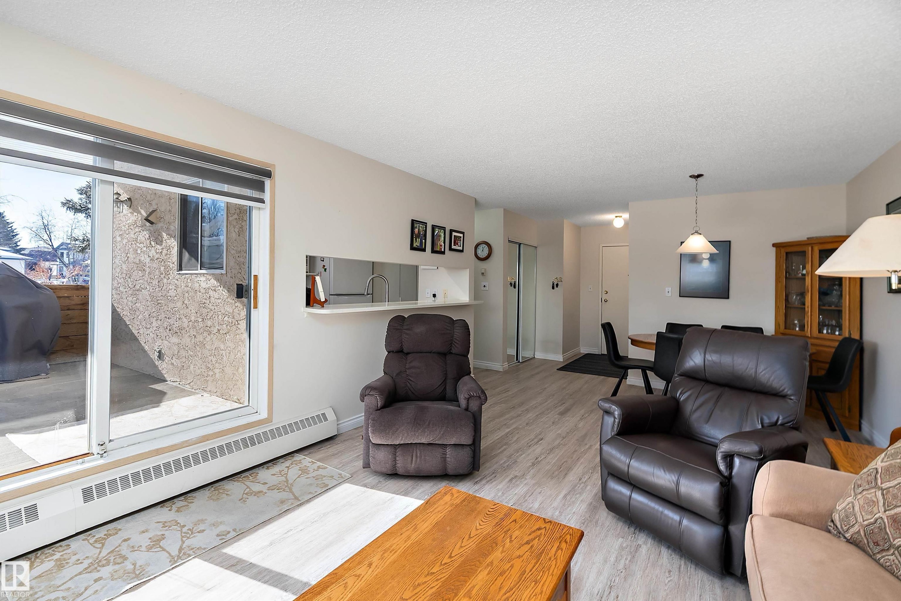 Living room featuring light flooring and sliding patio doors - 116 11620 9A Avenue, Edmonton, AB - Indoor Photo Showing Living Room