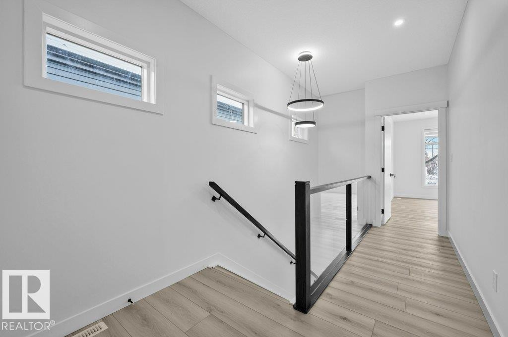 Stairs featuring healthy amount of natural light and wood finished floors - Edmonton, AB - Indoor Photo Showing Other Room