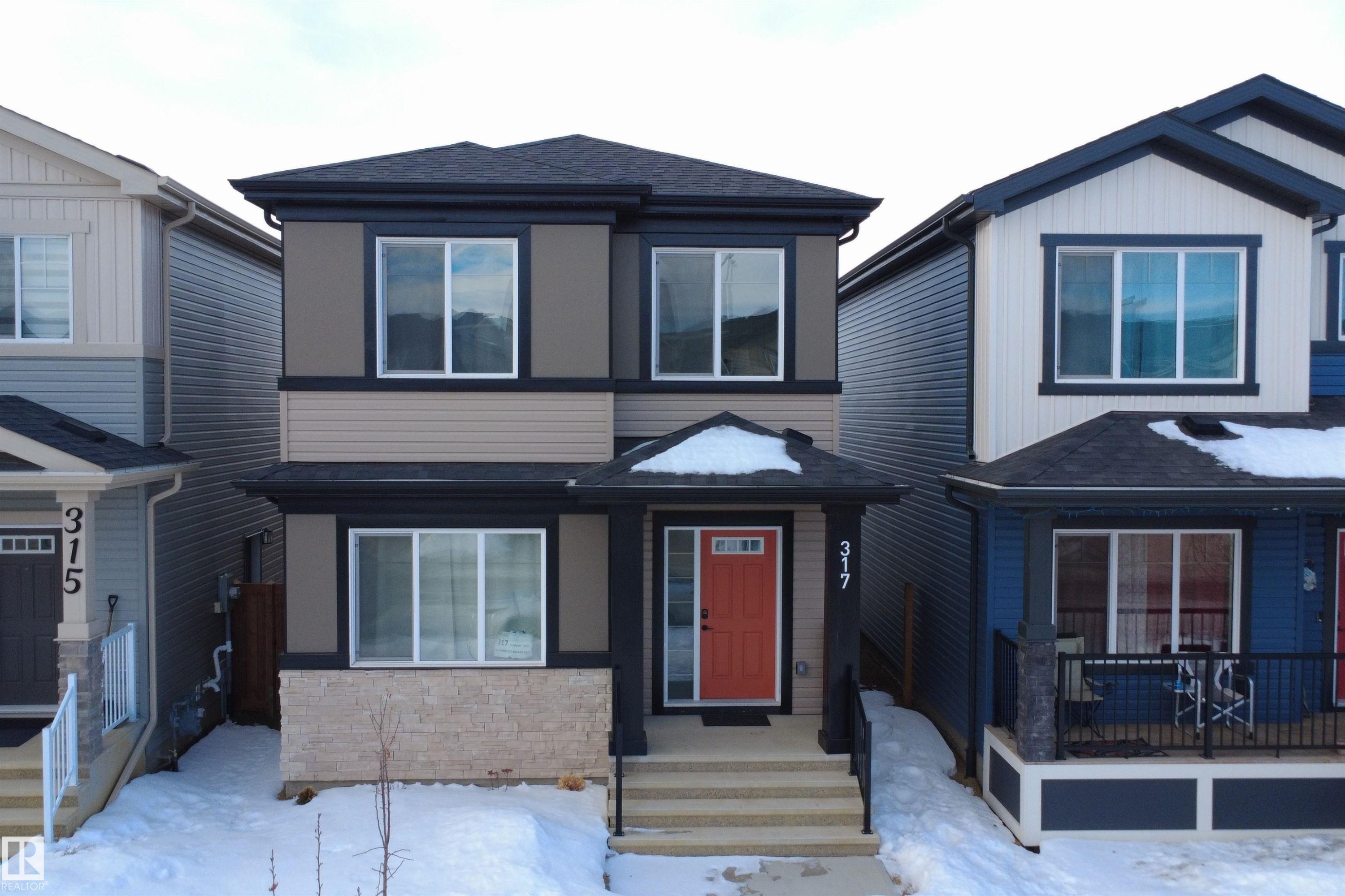 View of front of house featuring a shingled roof and stone siding - 317 Juniper Cove, Leduc, AB - Outdoor