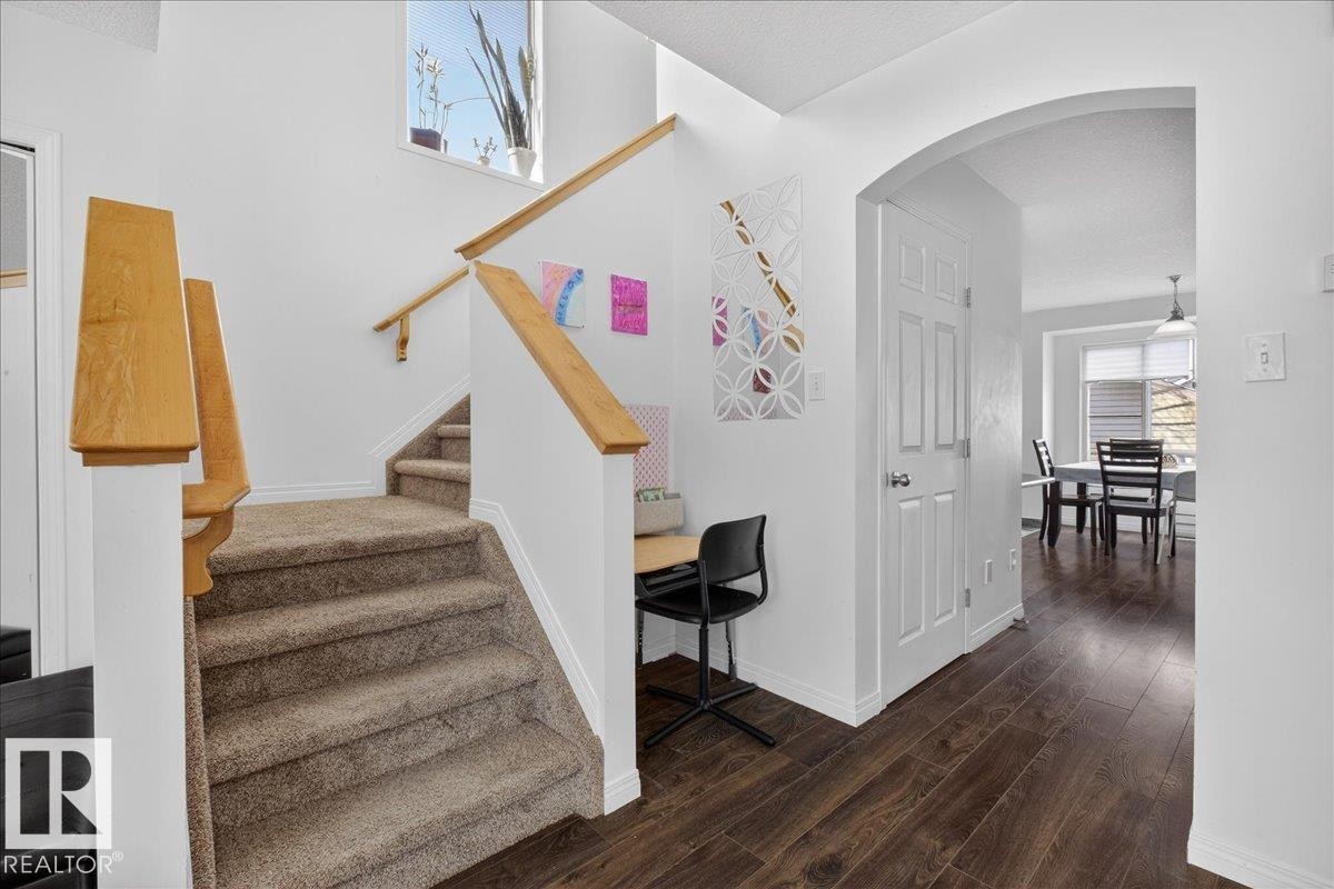Stairs with arched walkways and wood finished floors - 4519 Turner Square, Edmonton, AB - Indoor Photo Showing Other Room