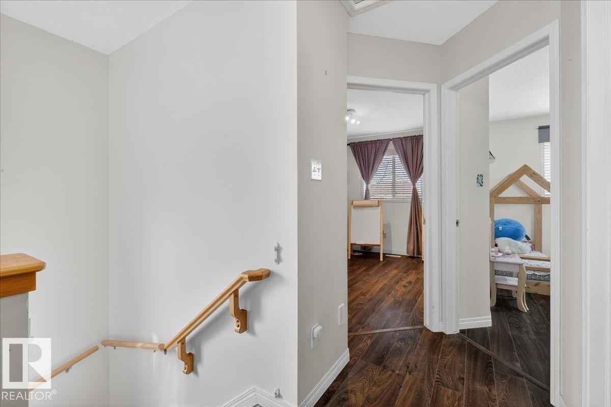 Hallway with dark wood-style floors and an upstairs landing - 4519 Turner Square, Edmonton, AB - Indoor Photo Showing Other Room