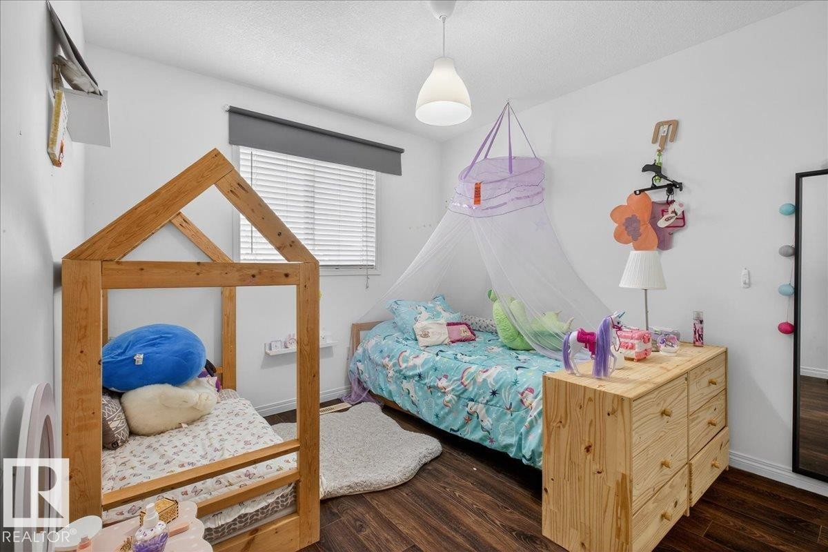 Bedroom with dark wood finished floors and a textured ceiling - 4519 Turner Square, Edmonton, AB - Indoor Photo Showing Bedroom