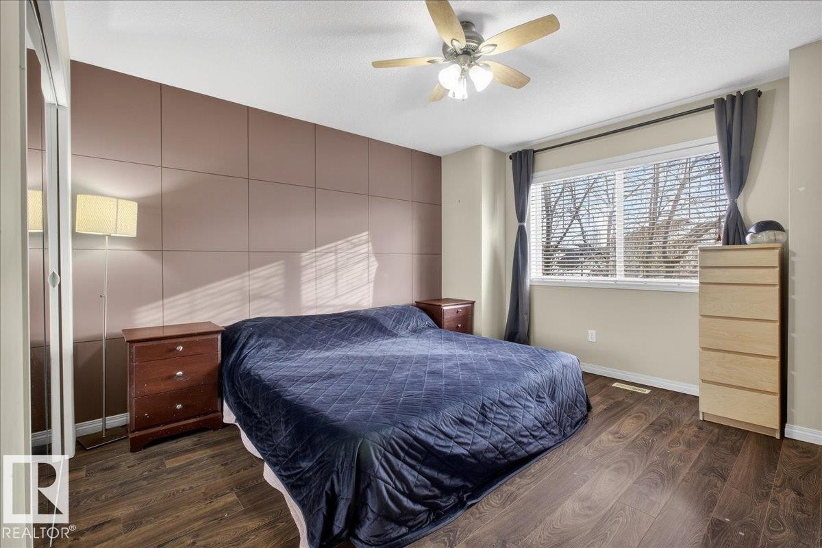 Bedroom with dark wood-type flooring, a ceiling fan, and a textured ceiling - 4519 Turner Square, Edmonton, AB - Indoor Photo Showing Bedroom