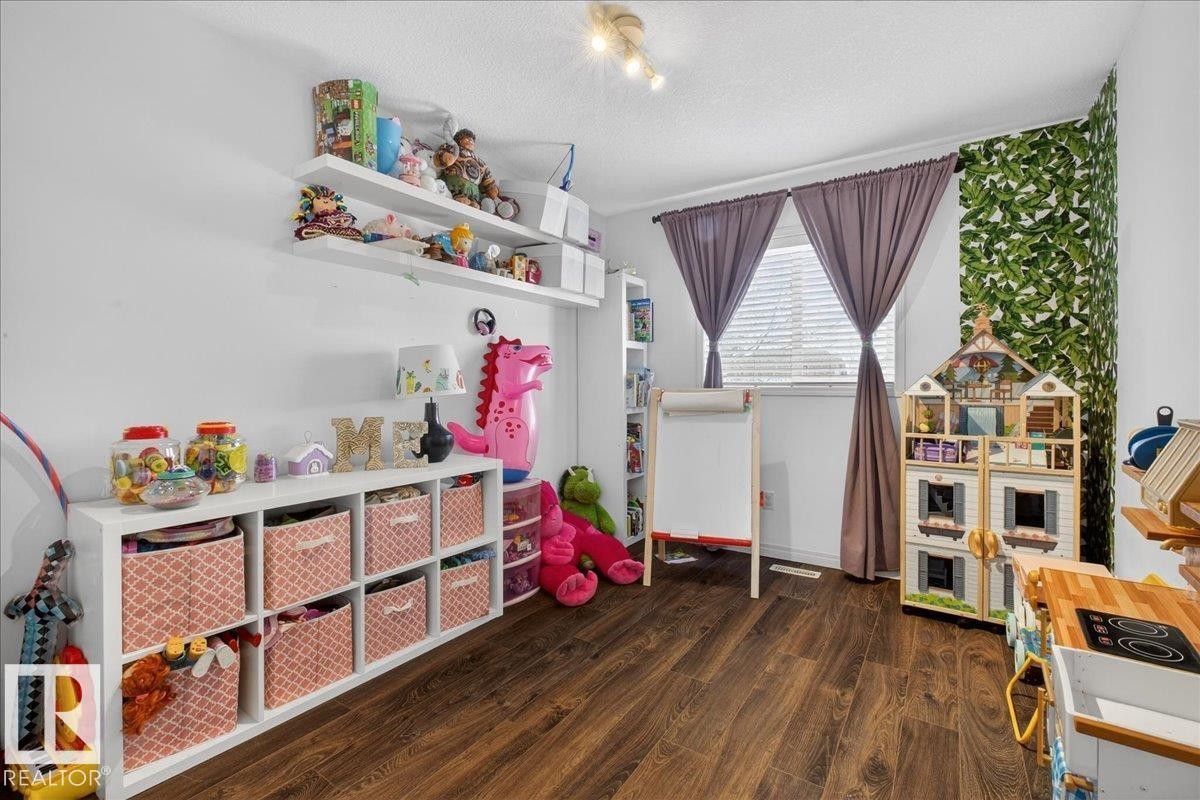 Game room featuring dark wood-type flooring and a textured ceiling - 4519 Turner Square, Edmonton, AB - Indoor
