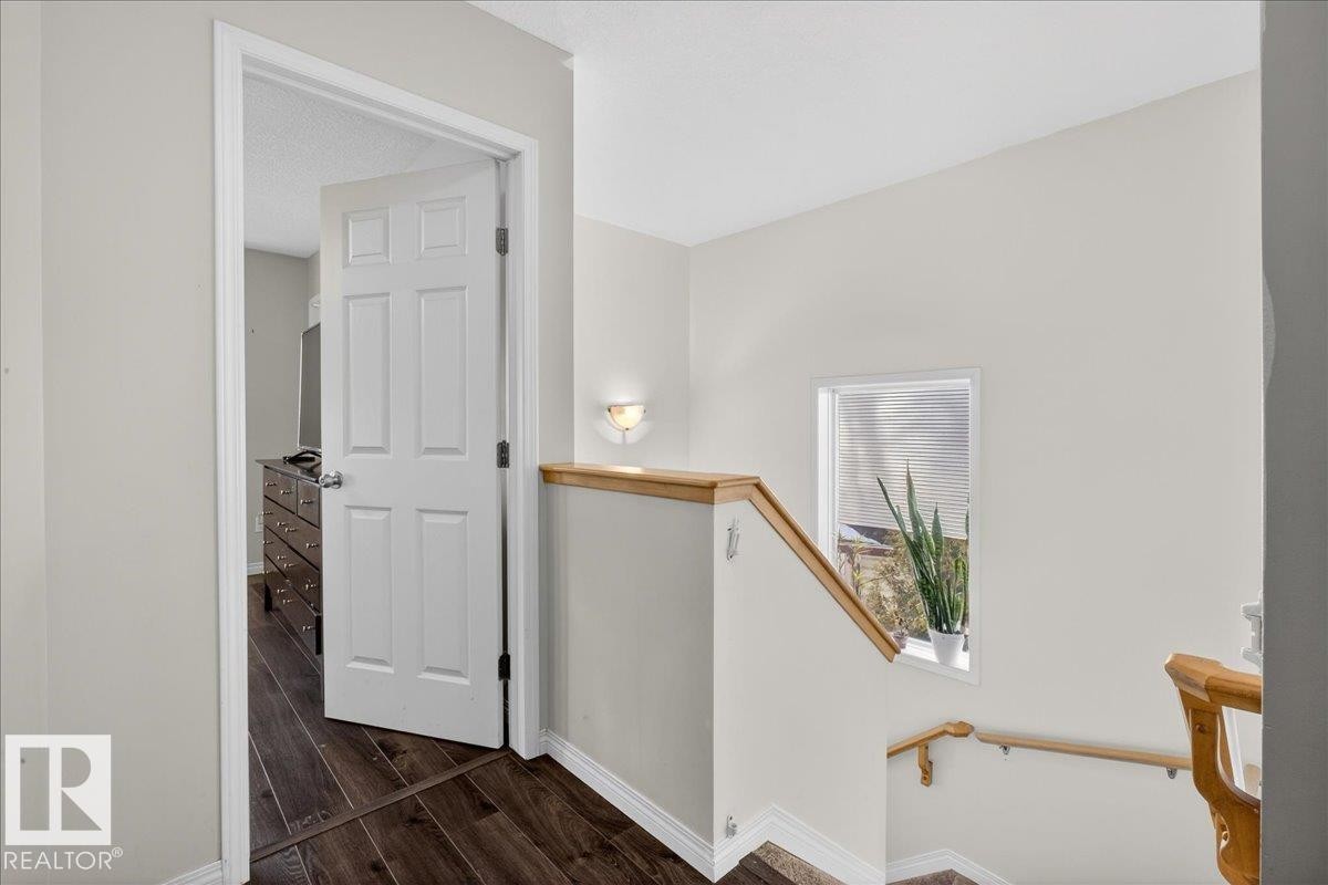 Hall featuring dark wood-style floors and an upstairs landing - 4519 Turner Square, Edmonton, AB - Indoor Photo Showing Other Room