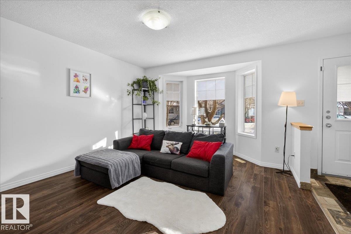Living area featuring a textured ceiling and dark wood-type flooring - 4519 Turner Square, Edmonton, AB - Indoor Photo Showing Living Room