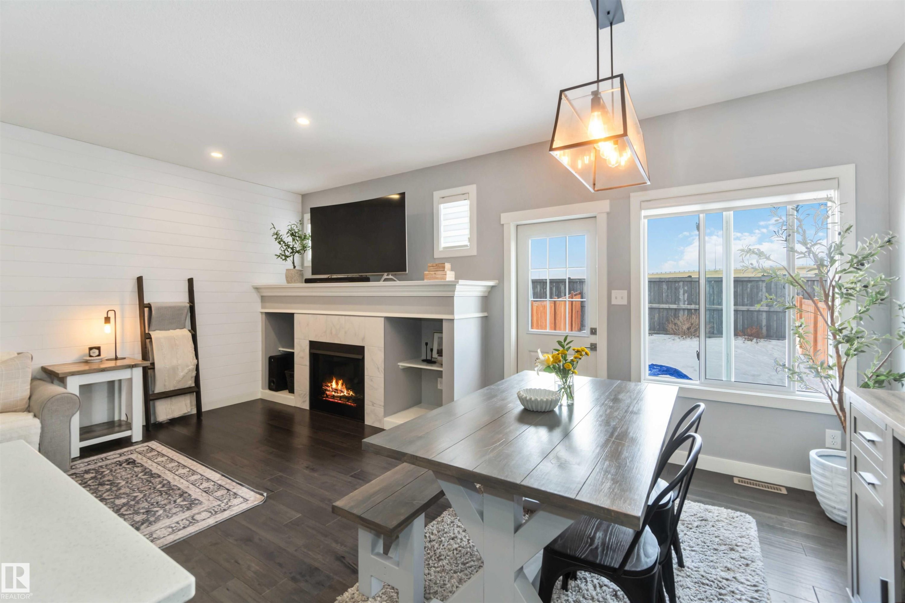 Dining space with dark wood finished floors, a tile fireplace, and recessed lighting - 17143 38 Street, Edmonton, AB - Indoor With Fireplace
