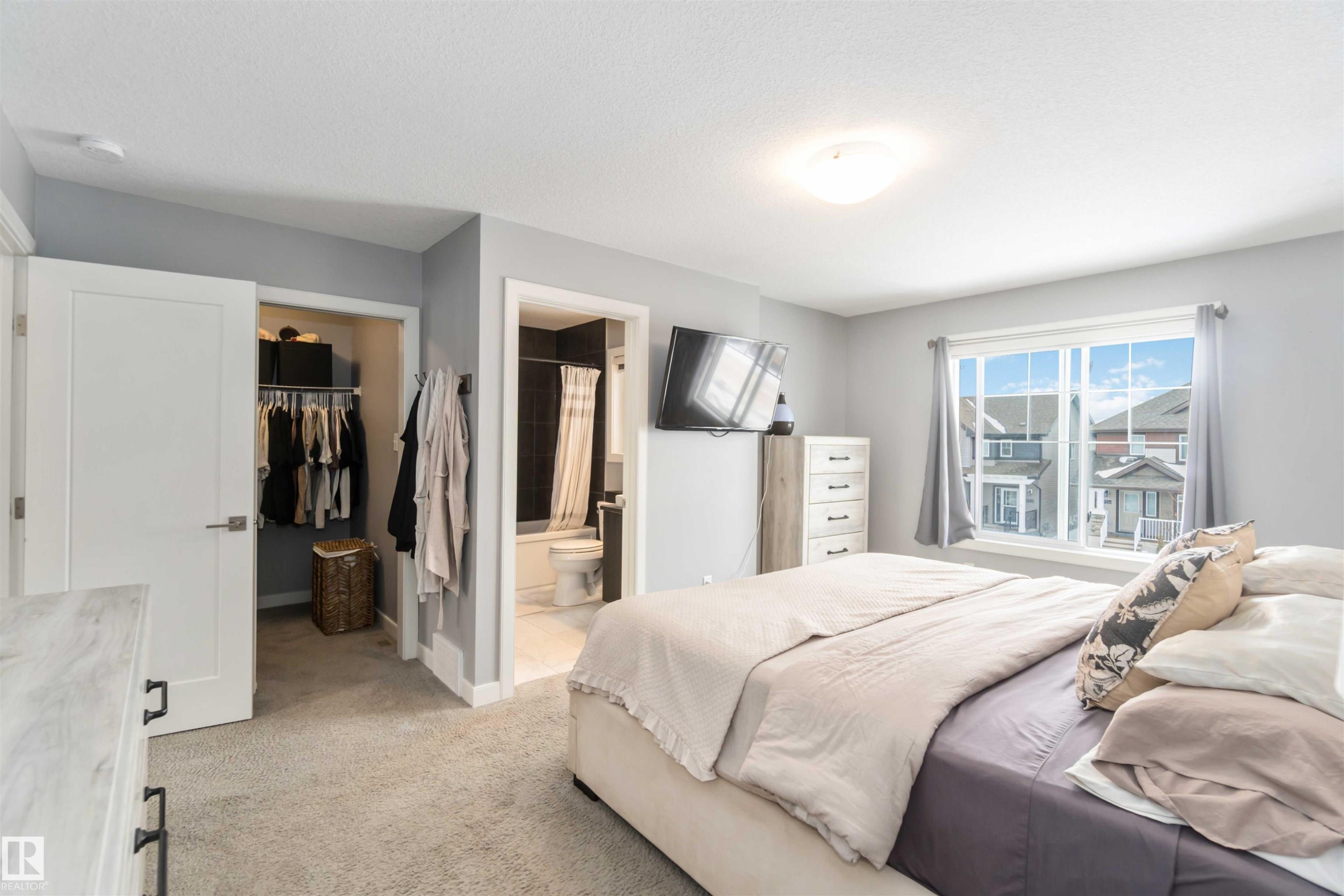 Bedroom featuring a walk in closet, light carpet, and connected bathroom - 17143 38 Street, Edmonton, AB - Indoor Photo Showing Bedroom
