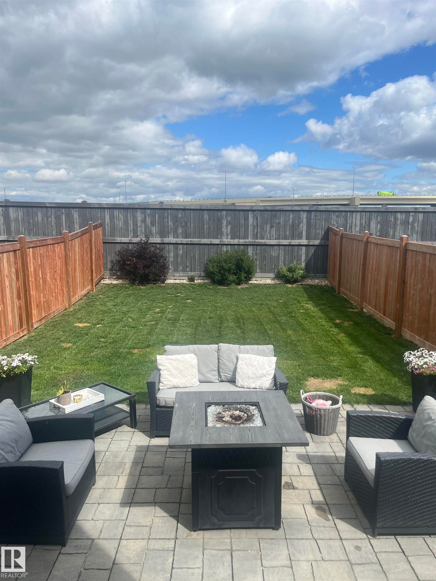 Fenced backyard with an outdoor living space with a fire pit and a patio - 17143 38 Street, Edmonton, AB - Outdoor With Deck Patio Veranda