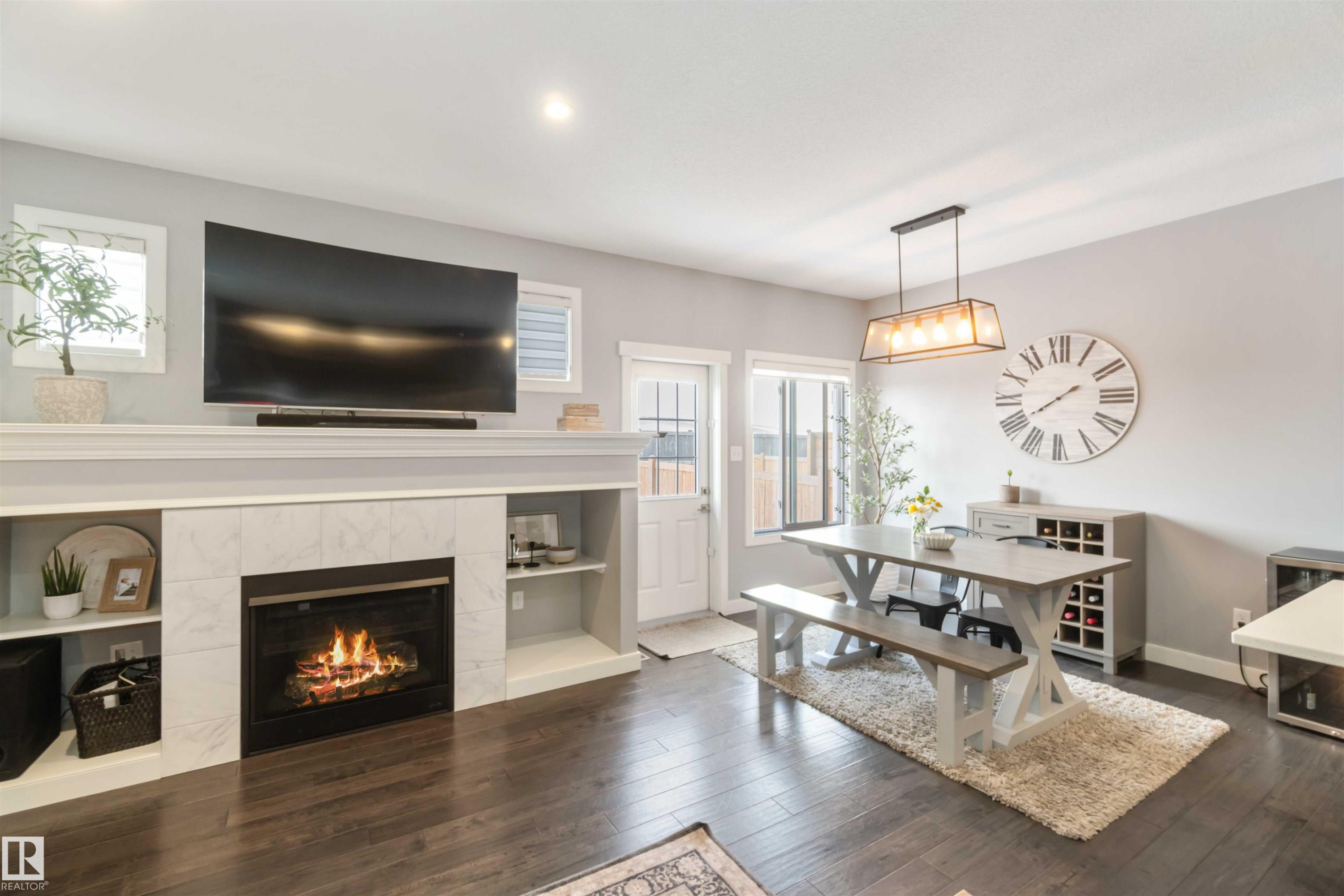 Dining space with a tiled fireplace and dark wood finished floors - 17143 38 Street, Edmonton, AB - Indoor Photo Showing Living Room With Fireplace