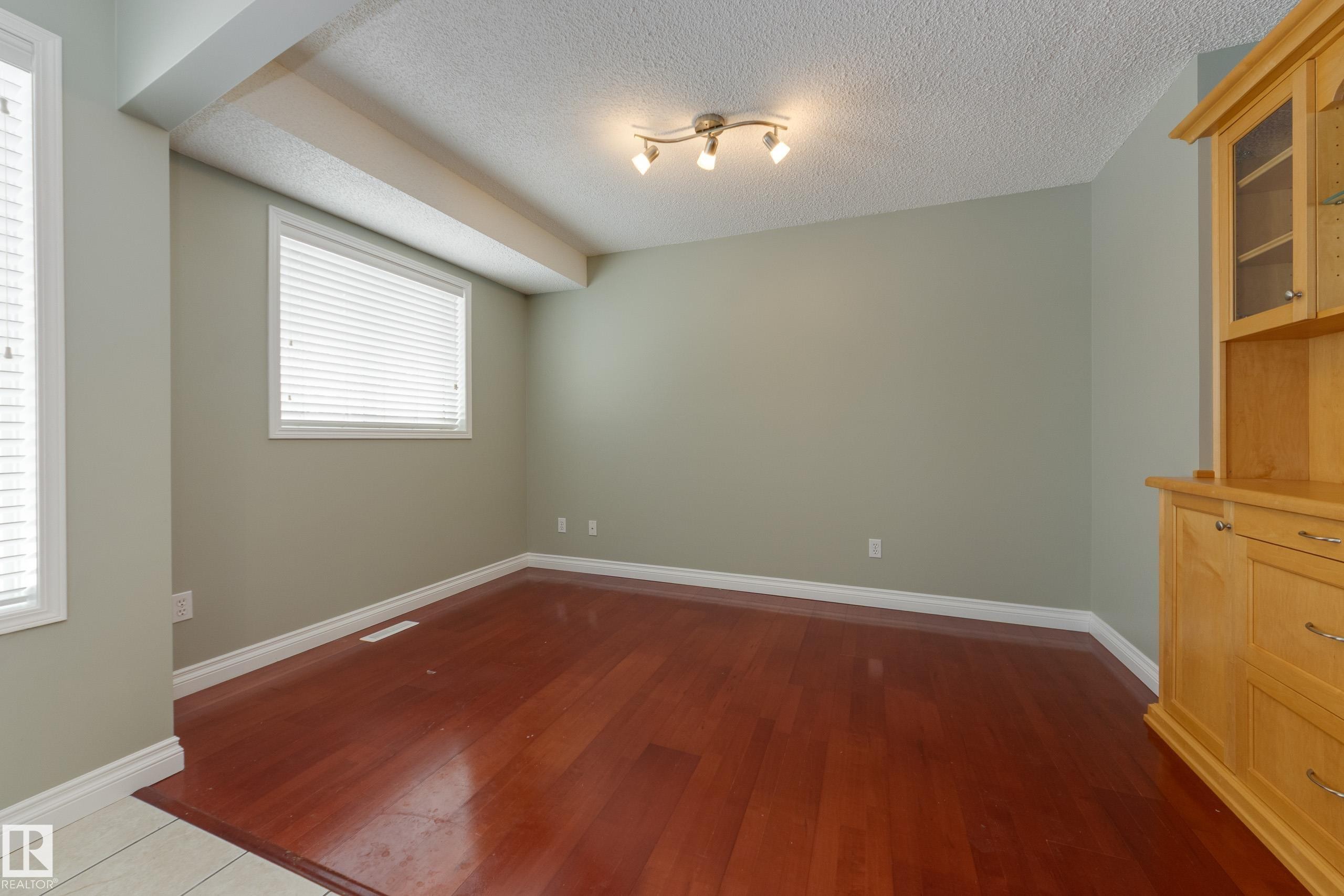 Unfurnished room featuring dark wood-style floors and a textured ceiling - 9916 178 Avenue, Edmonton, AB - Indoor Photo Showing Other Room