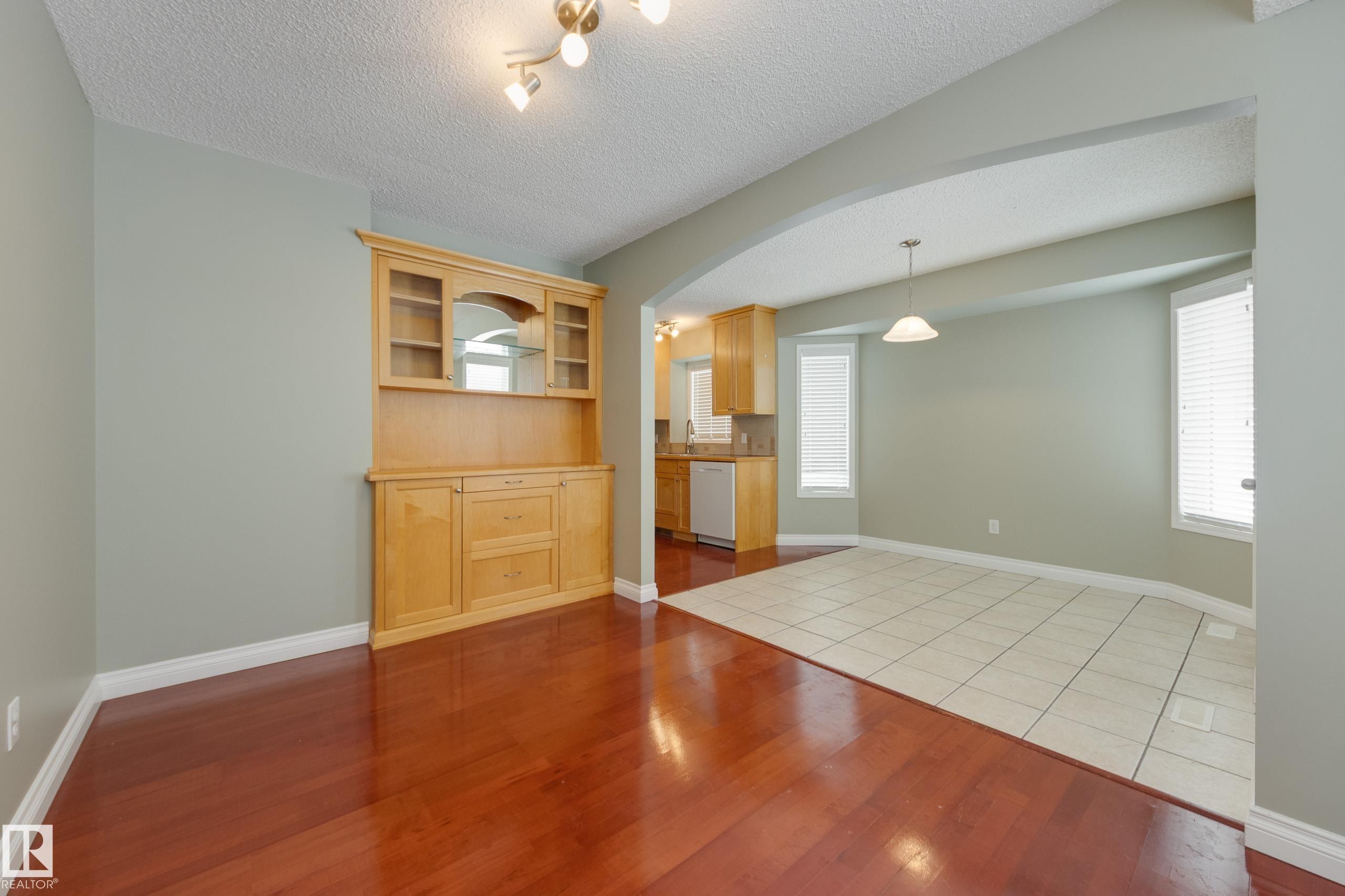 Empty room featuring arched walkways, dark tile patterned floors, and a textured ceiling - 9916 178 Avenue, Edmonton, AB - Indoor Photo Showing Other Room