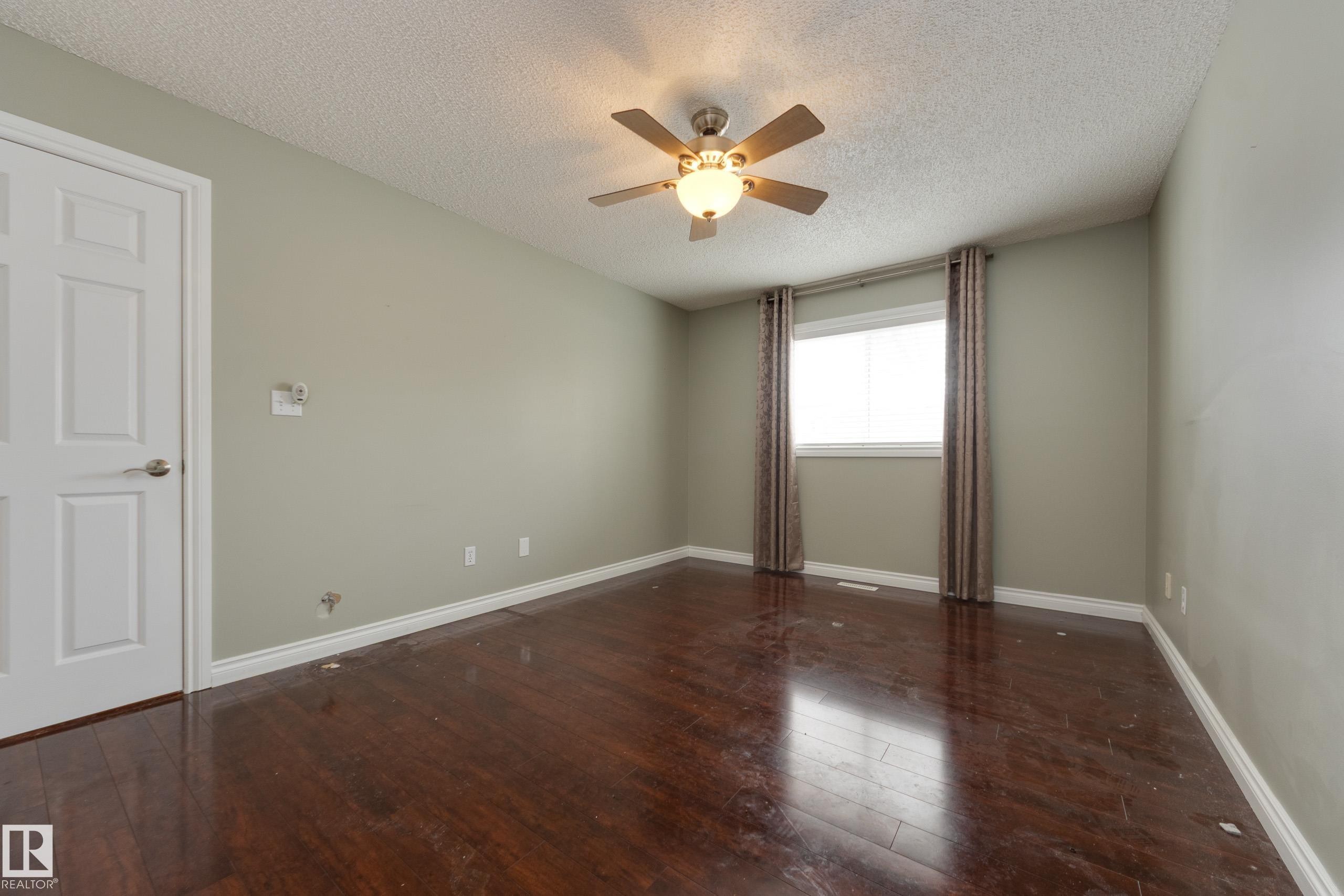 Unfurnished room with dark wood finished floors, a textured ceiling, and a ceiling fan - 9916 178 Avenue, Edmonton, AB - Indoor Photo Showing Other Room
