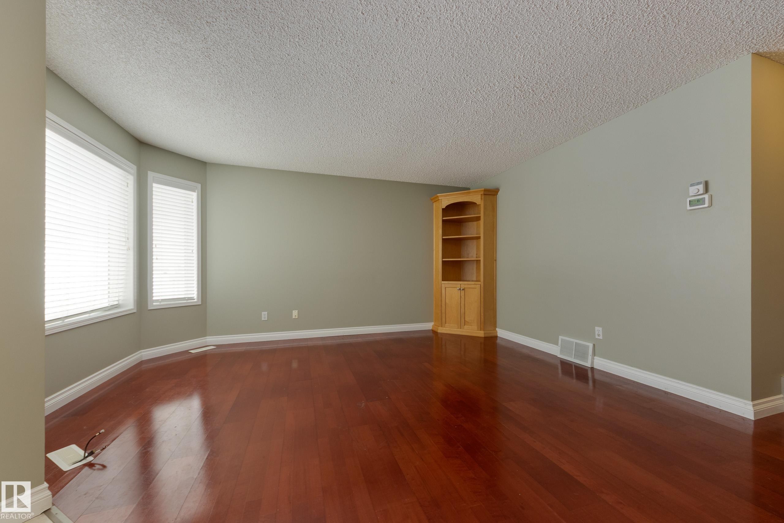 Empty room with dark wood-style floors and a textured ceiling - 9916 178 Avenue, Edmonton, AB - Indoor Photo Showing Other Room