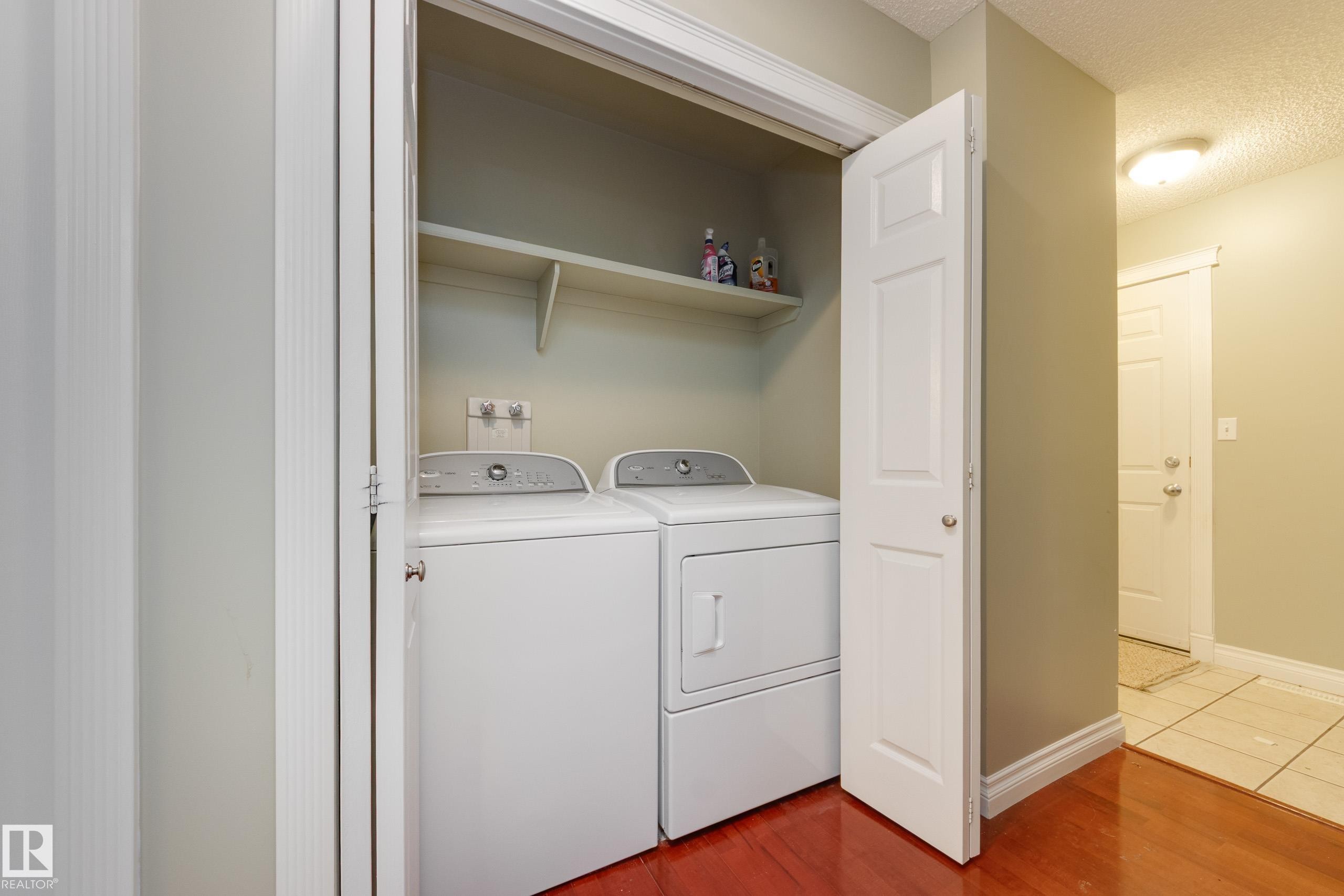 Laundry area featuring washer and clothes dryer, light wood-type flooring, and a textured ceiling - 9916 178 Avenue, Edmonton, AB - Indoor Photo Showing Laundry Room