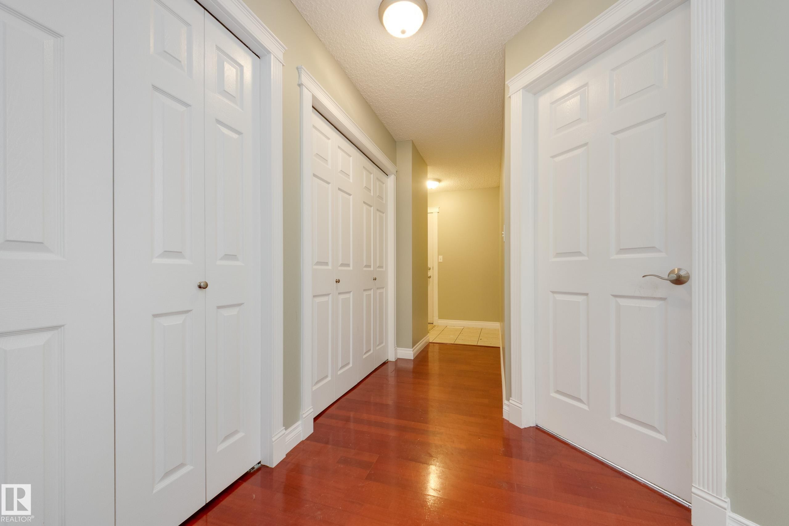 Hall with dark wood finished floors and a textured ceiling - 9916 178 Avenue, Edmonton, AB - Indoor Photo Showing Other Room