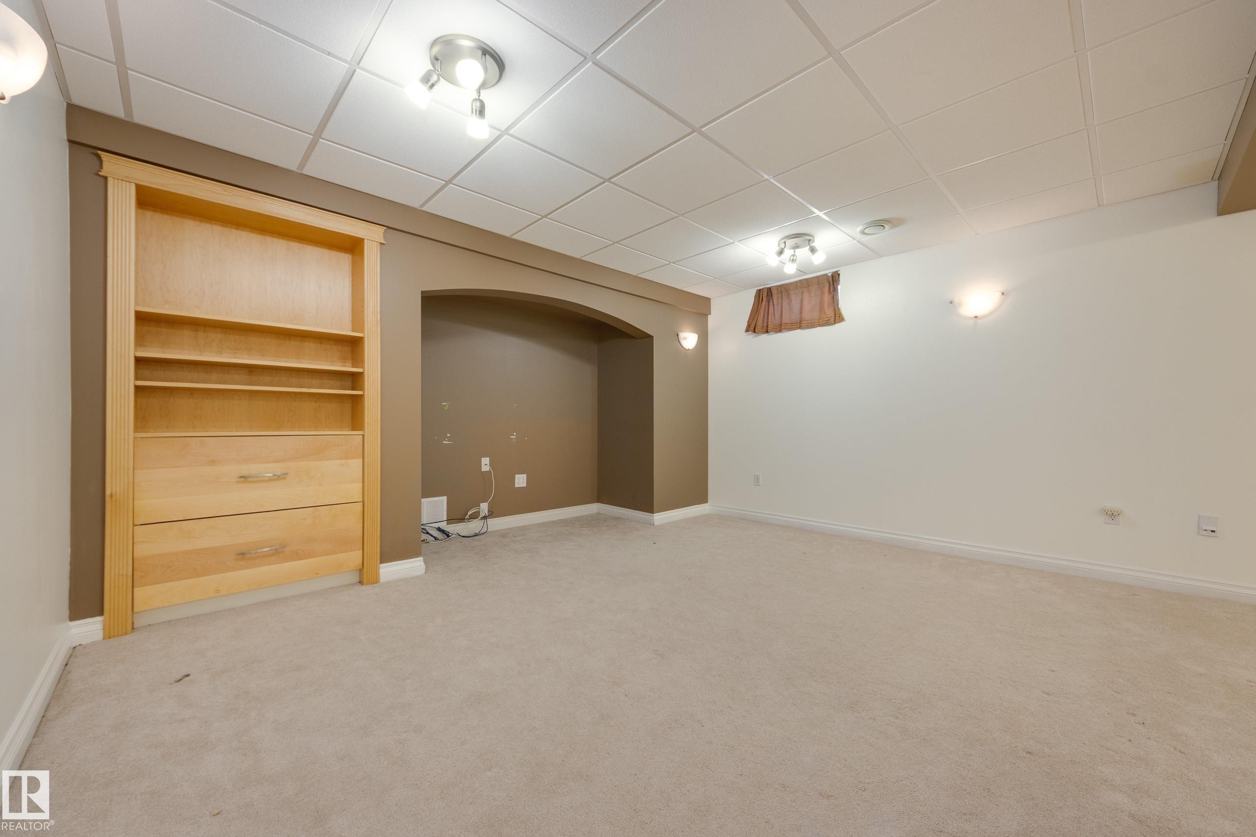 Finished basement with a paneled ceiling, light colored carpet, and built in features - 9916 178 Avenue, Edmonton, AB - Indoor