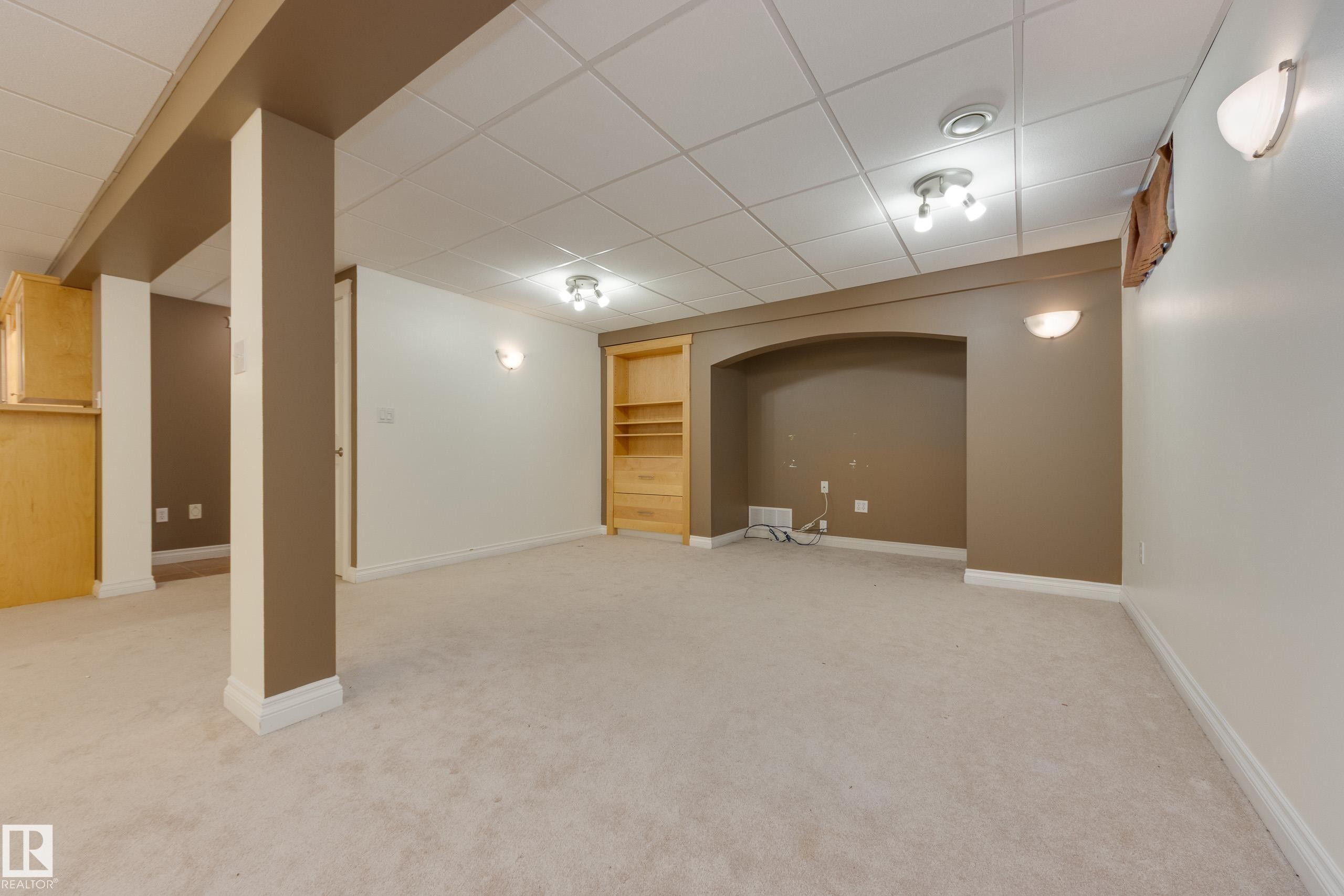 Finished basement with a paneled ceiling, light carpet, and built in features - 9916 178 Avenue, Edmonton, AB - Indoor