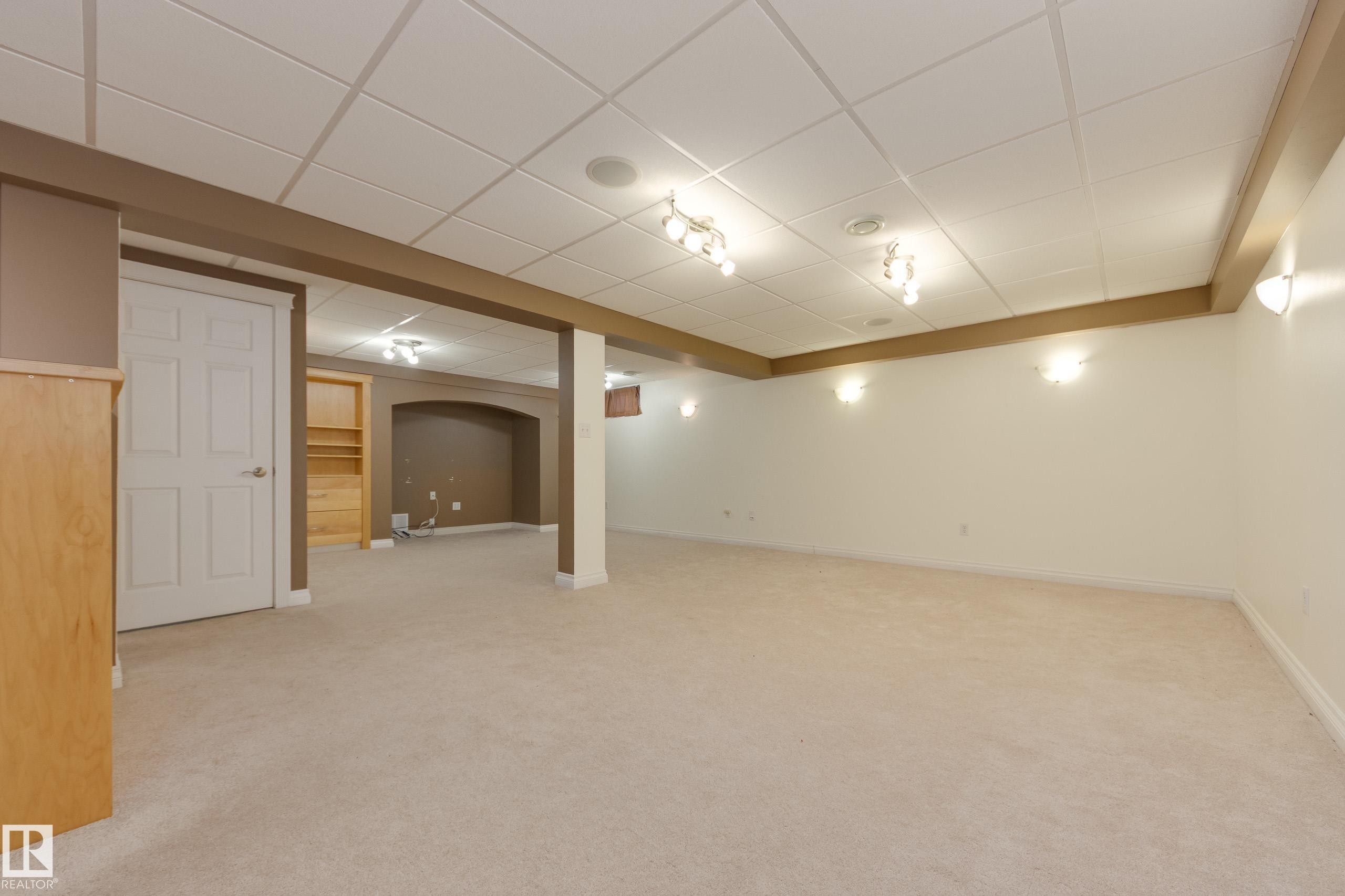 Finished below grade area featuring a paneled ceiling and light colored carpet - 9916 178 Avenue, Edmonton, AB - Indoor
