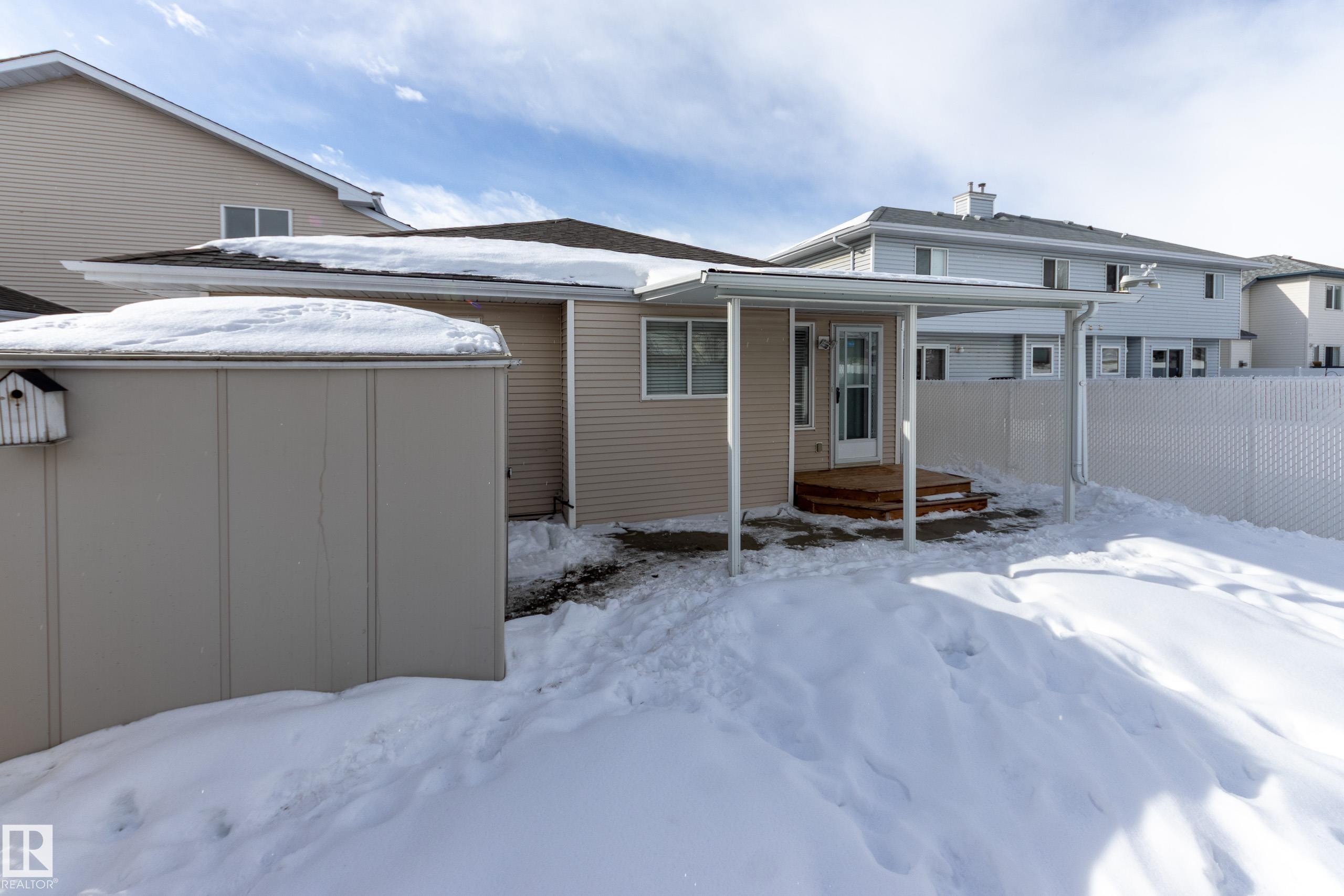 Snow covered rear of property with a storage unit, a chimney, and a deck - 9916 178 Avenue, Edmonton, AB - Outdoor