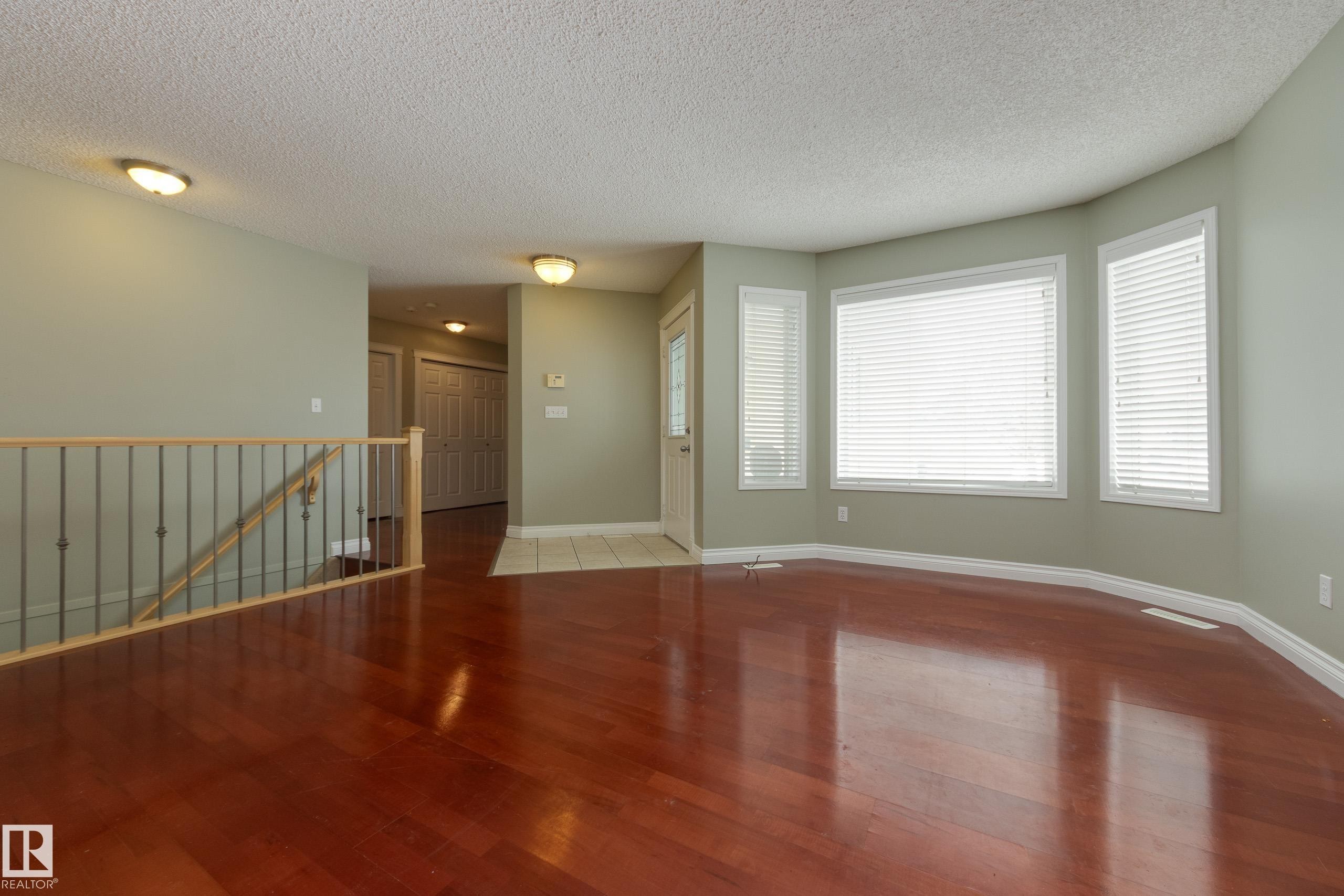 Unfurnished living room featuring wood finished floors and a textured ceiling - 9916 178 Avenue, Edmonton, AB - Indoor Photo Showing Other Room