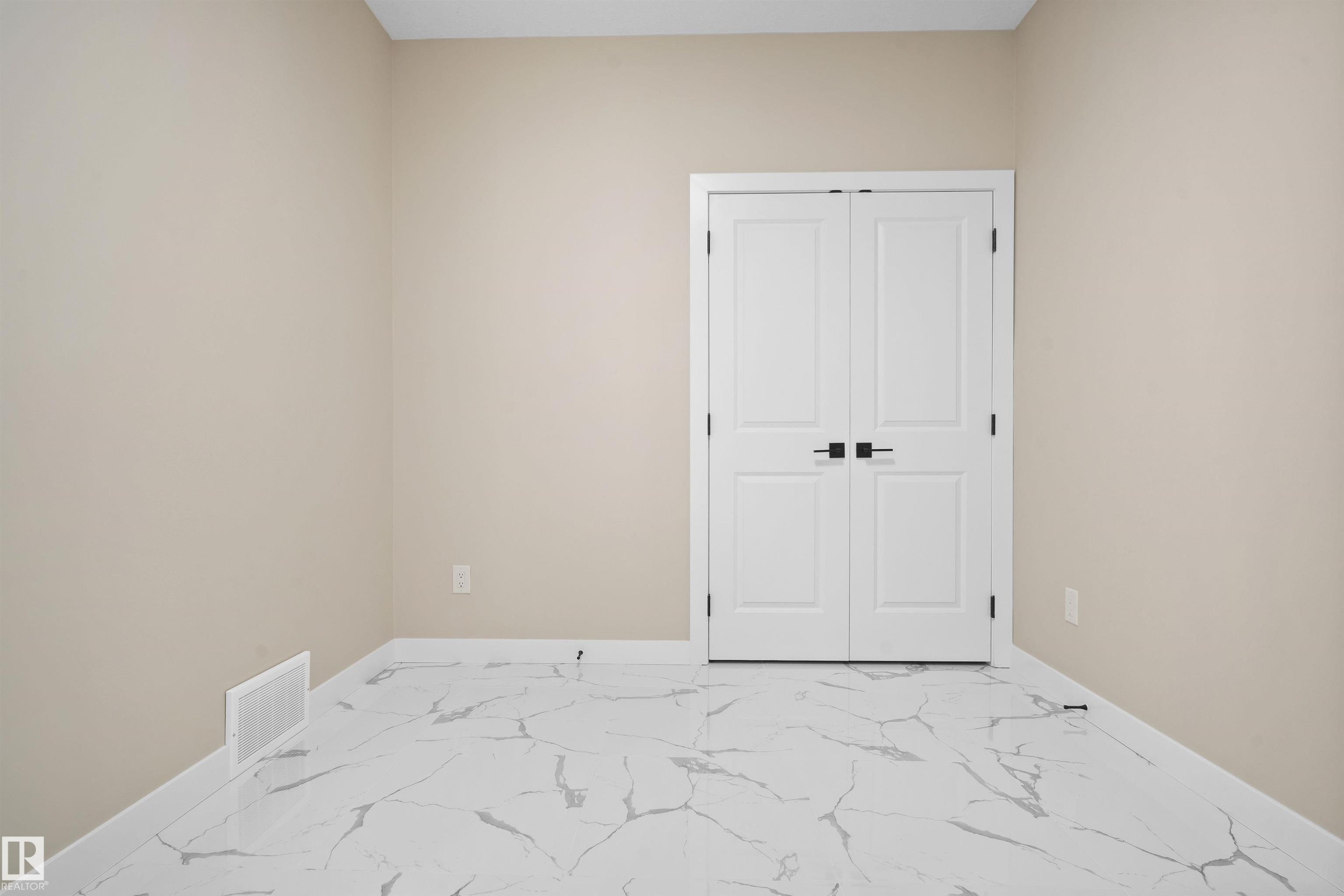 Unfurnished bedroom with light marble finish floors and a closet - 3910 41 Avenue, Beaumont, AB - Indoor