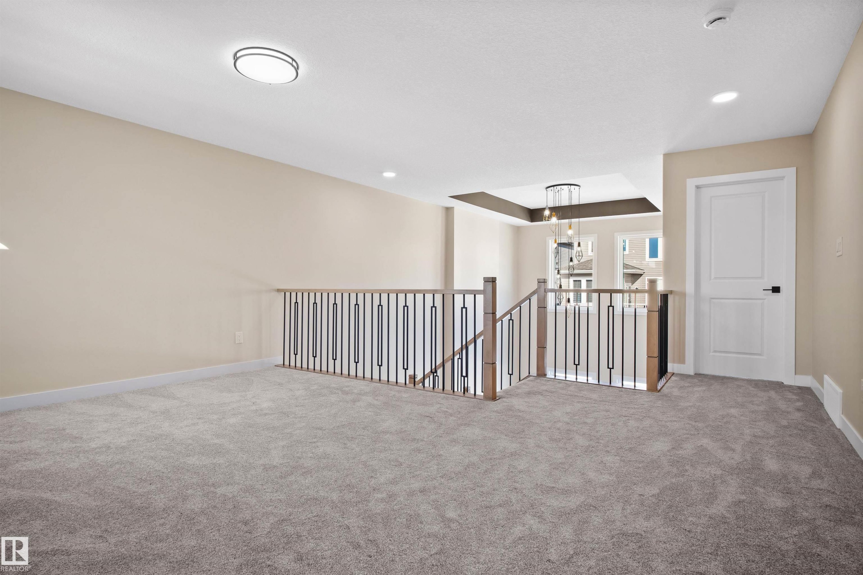 Carpeted empty room featuring baseboards and a chandelier - 3910 41 Avenue, Beaumont, AB - Indoor Photo Showing Other Room