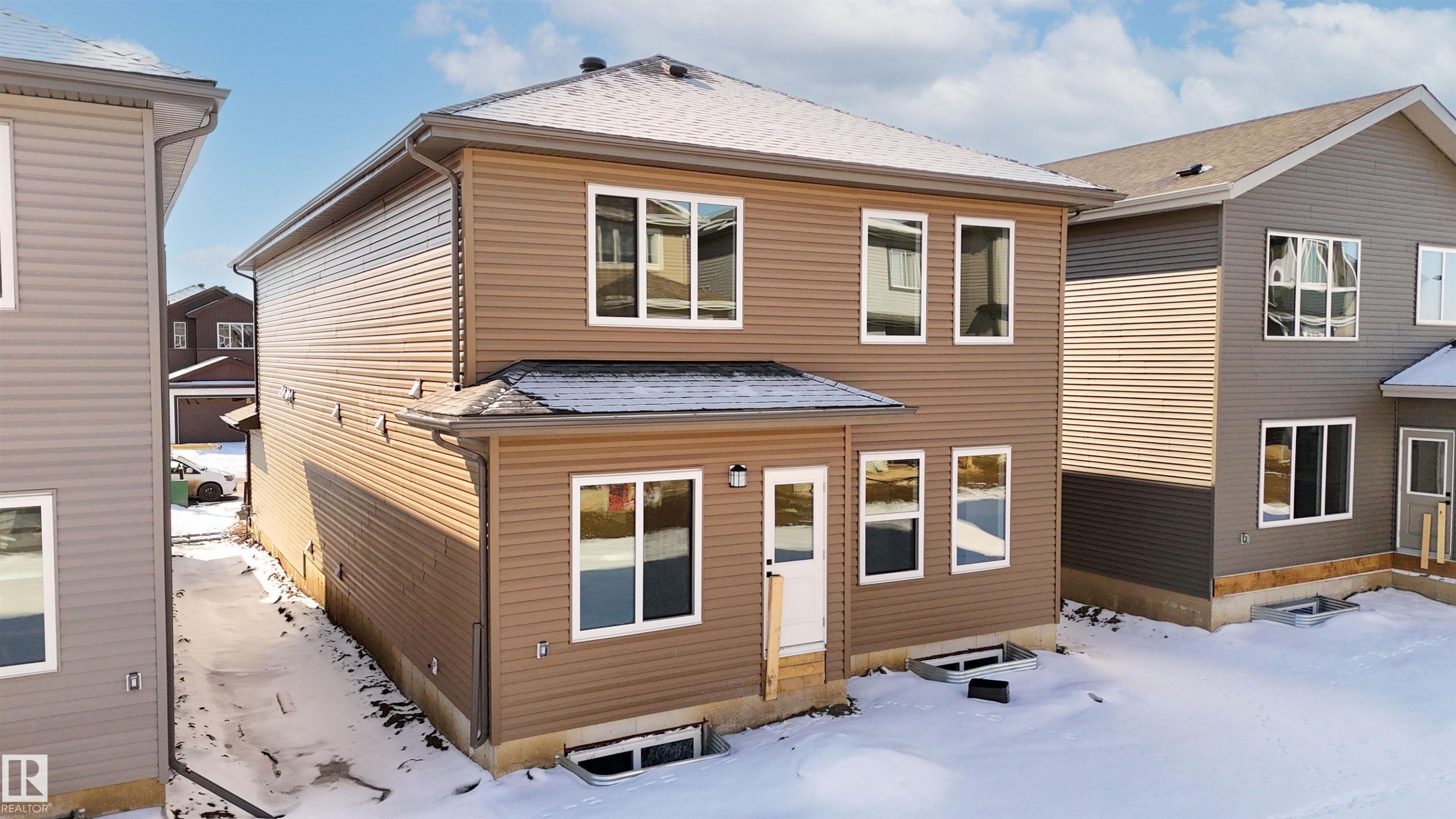 Snow covered house featuring a shingled roof and entry steps - 3910 41 Avenue, Beaumont, AB - Outdoor With Exterior
