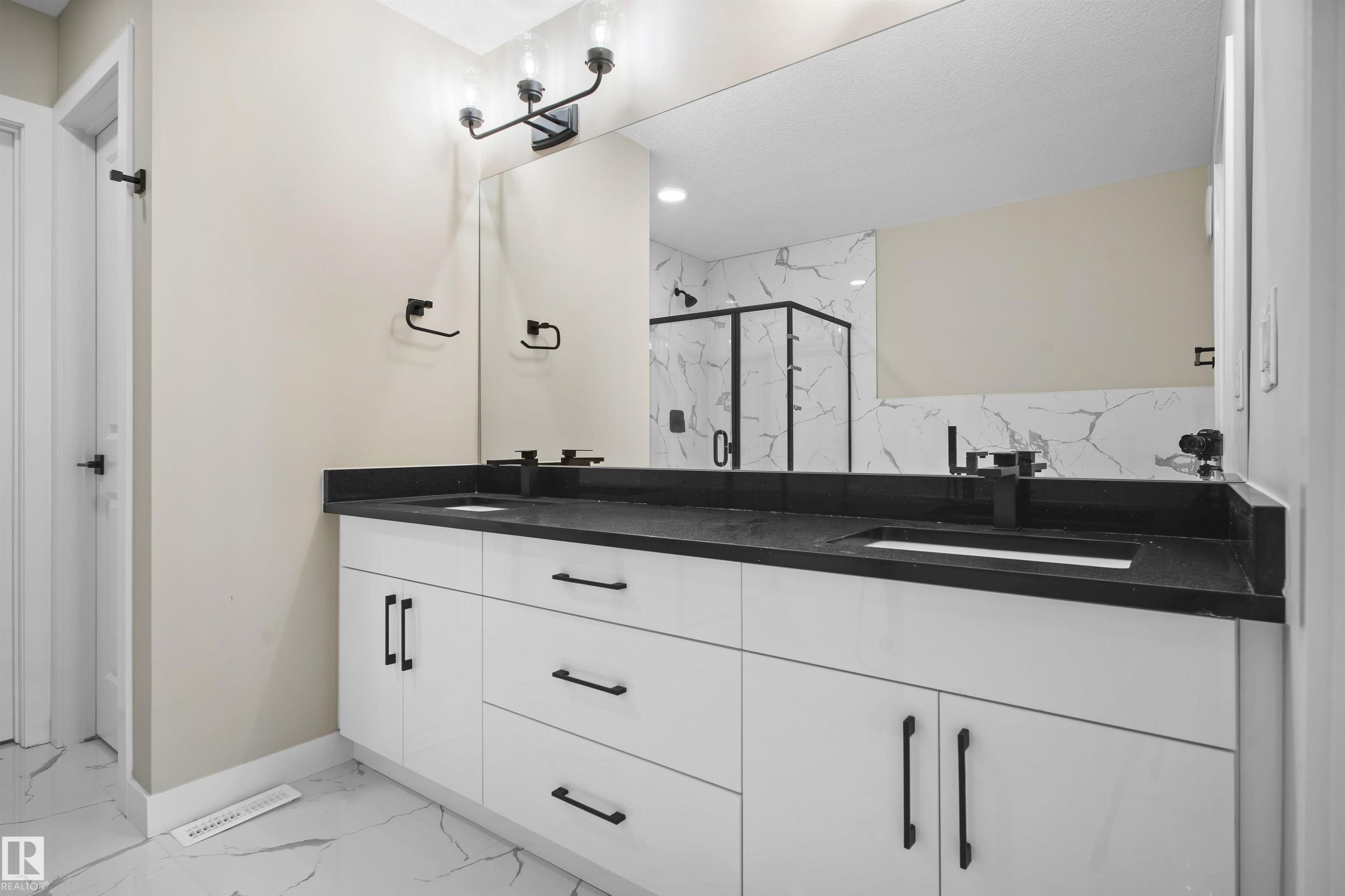 Full bath with double vanity, light marble finish flooring, and a marble finish shower - 3910 41 Avenue, Beaumont, AB - Indoor Photo Showing Bathroom