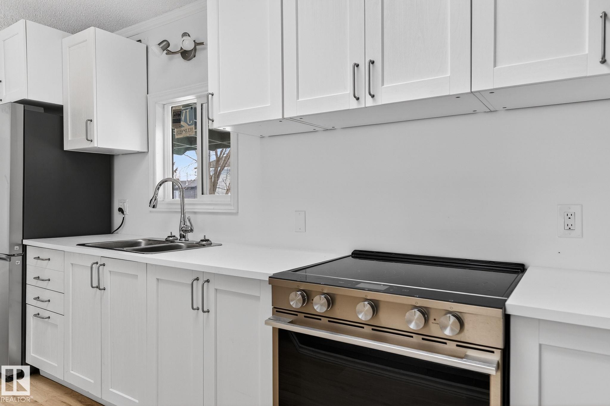 Kitchen with stainless steel appliances, white cabinetry, ornamental molding, and light wood-style flooring - 72 Evergreen Park, Edmonton, AB - Indoor Photo Showing Kitchen With Double Sink