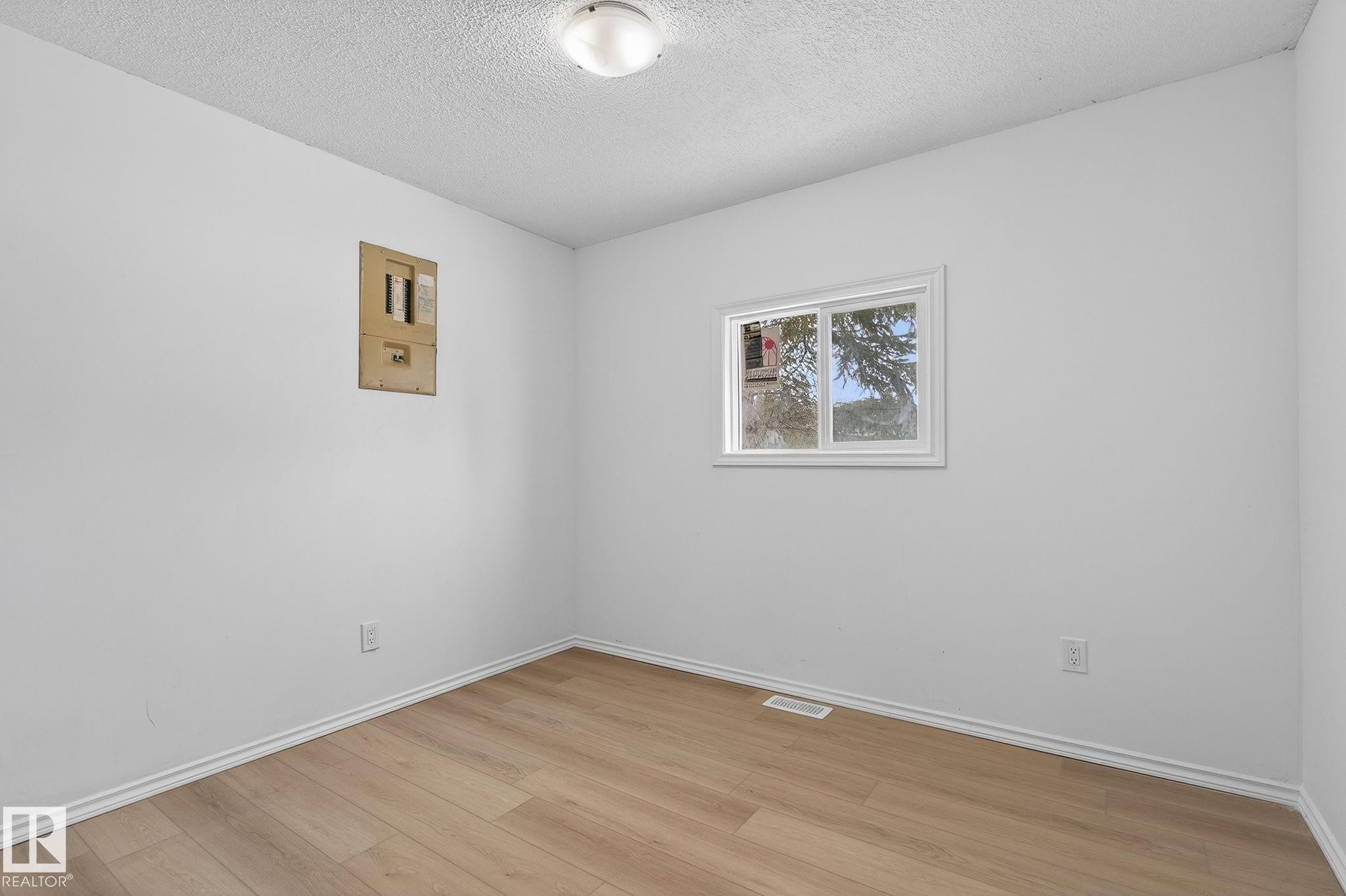 Empty room featuring a textured ceiling and light wood-style floors - 72 Evergreen Park, Edmonton, AB - Indoor Photo Showing Other Room