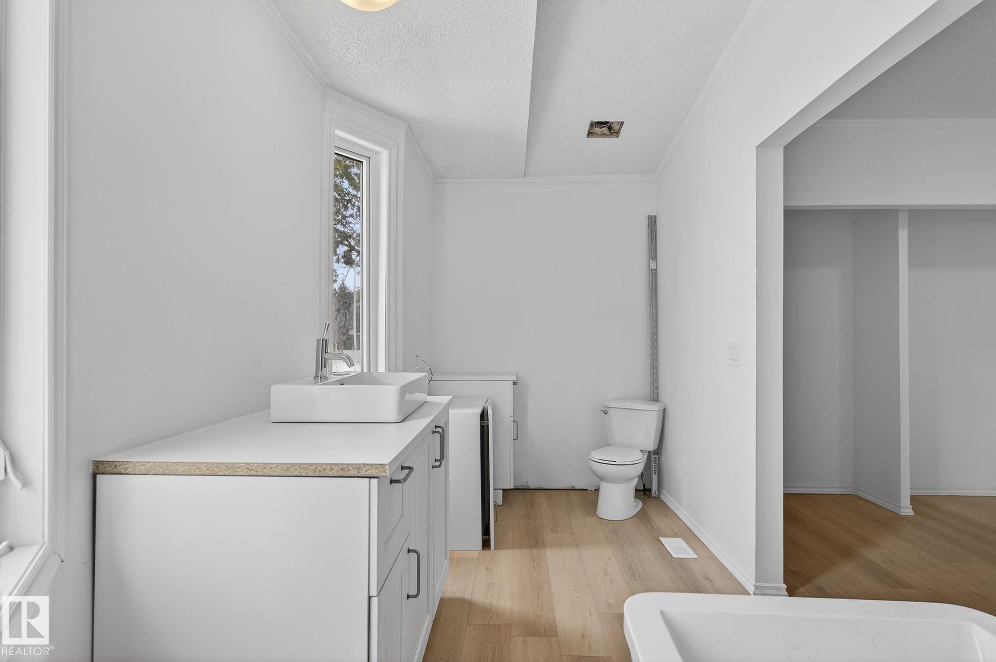 Full bath featuring light wood finished floors, vanity, ornamental molding, and a textured ceiling - 72 Evergreen Park, Edmonton, AB - Indoor