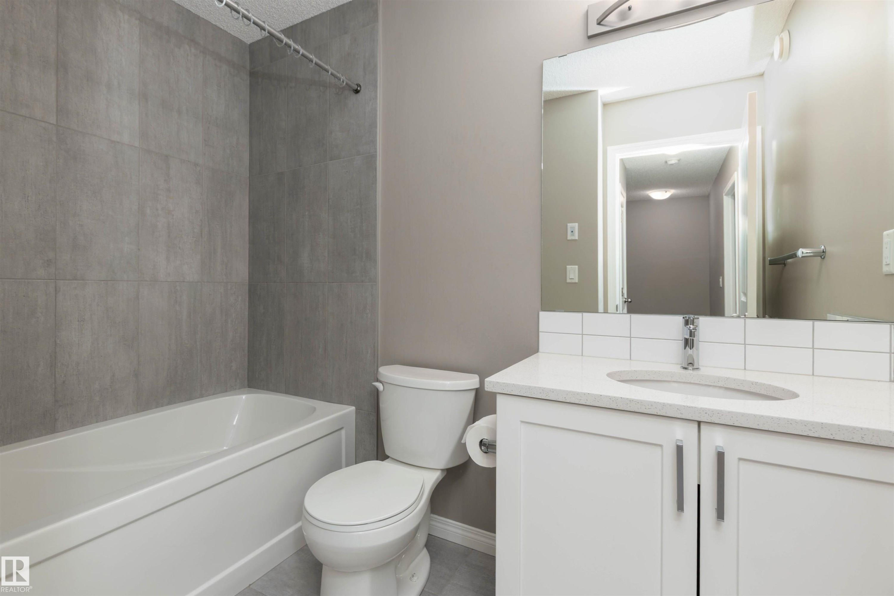Bathroom featuring vanity, bathtub / shower combination - 105 2072 Wonnacott Way, Edmonton, AB - Indoor Photo Showing Bathroom