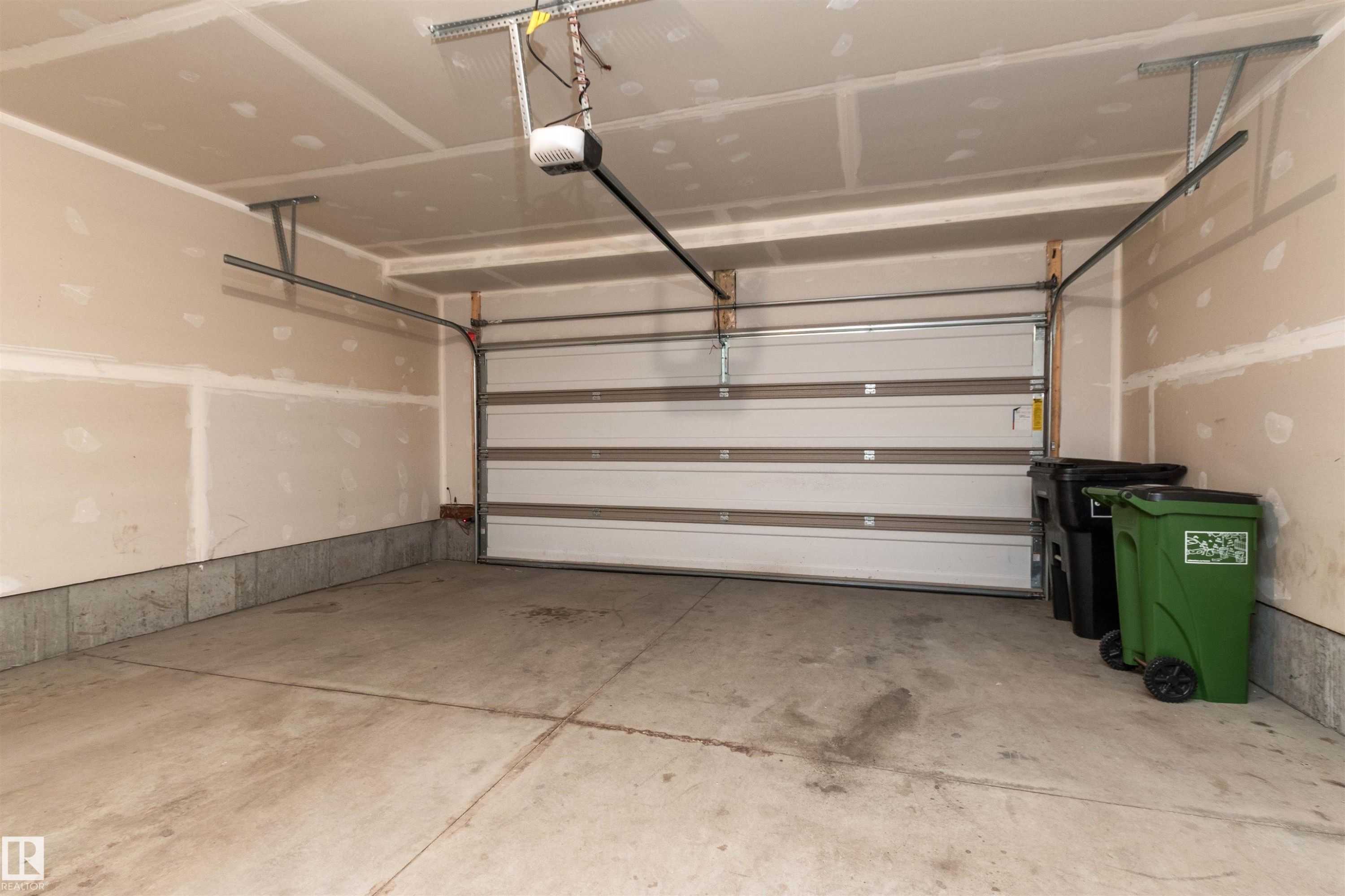 Garage with a garage door opener - 105 2072 Wonnacott Way, Edmonton, AB - Indoor Photo Showing Garage