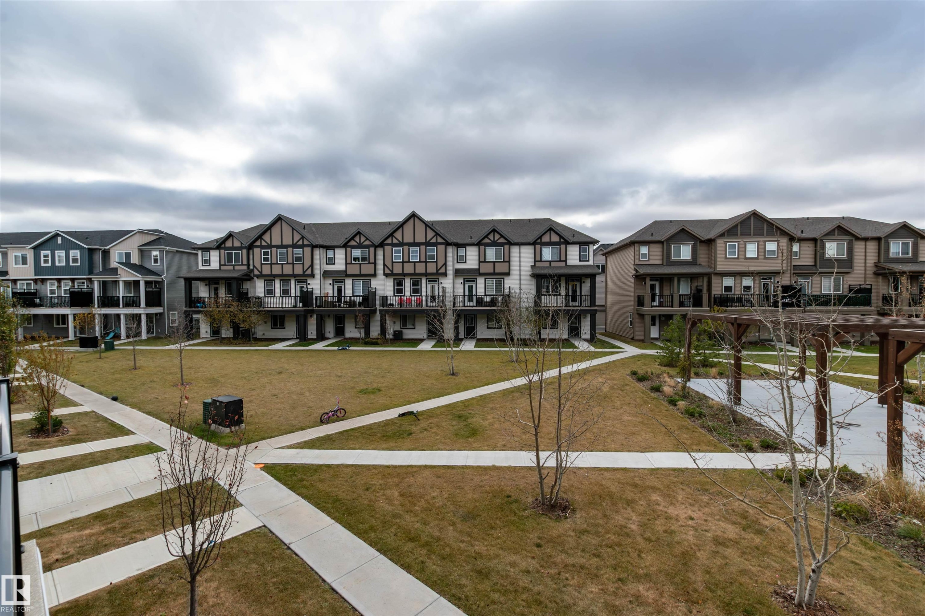 View of community with a residential view and a yard - 105 2072 Wonnacott Way, Edmonton, AB - Outdoor With Facade