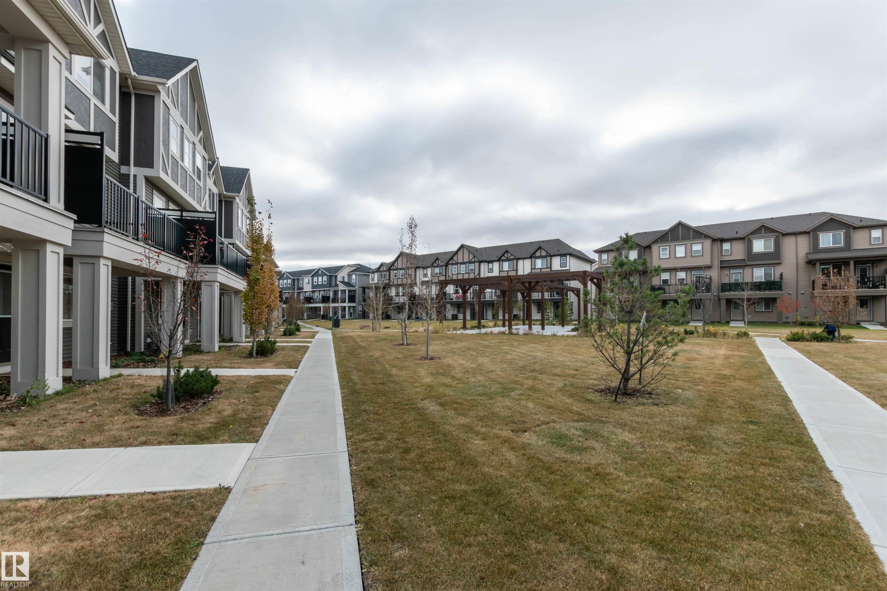 Surrounding community with a residential view and a yard - 105 2072 Wonnacott Way, Edmonton, AB - Outdoor With Facade