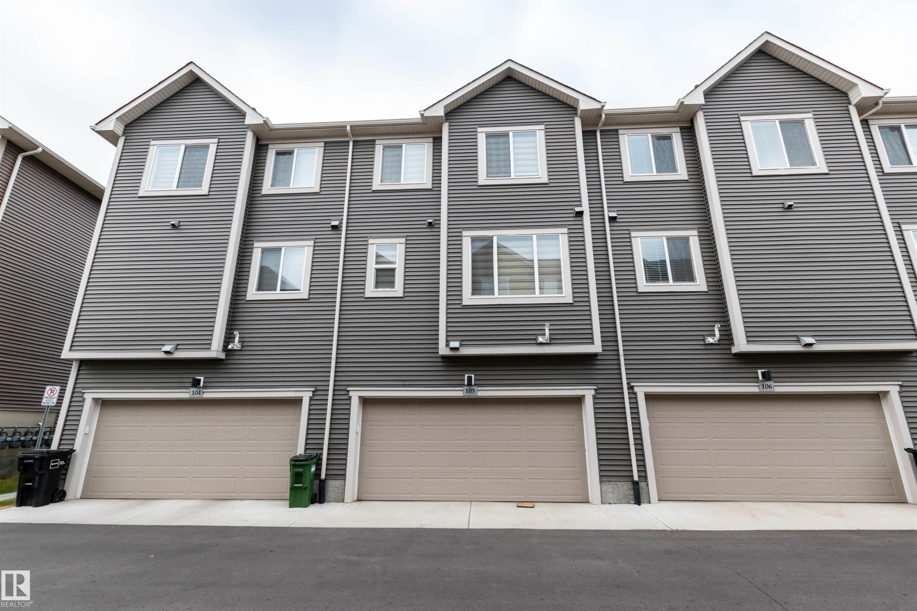 Back of property featuring an attached garage and driveway - 105 2072 Wonnacott Way, Edmonton, AB - Outdoor