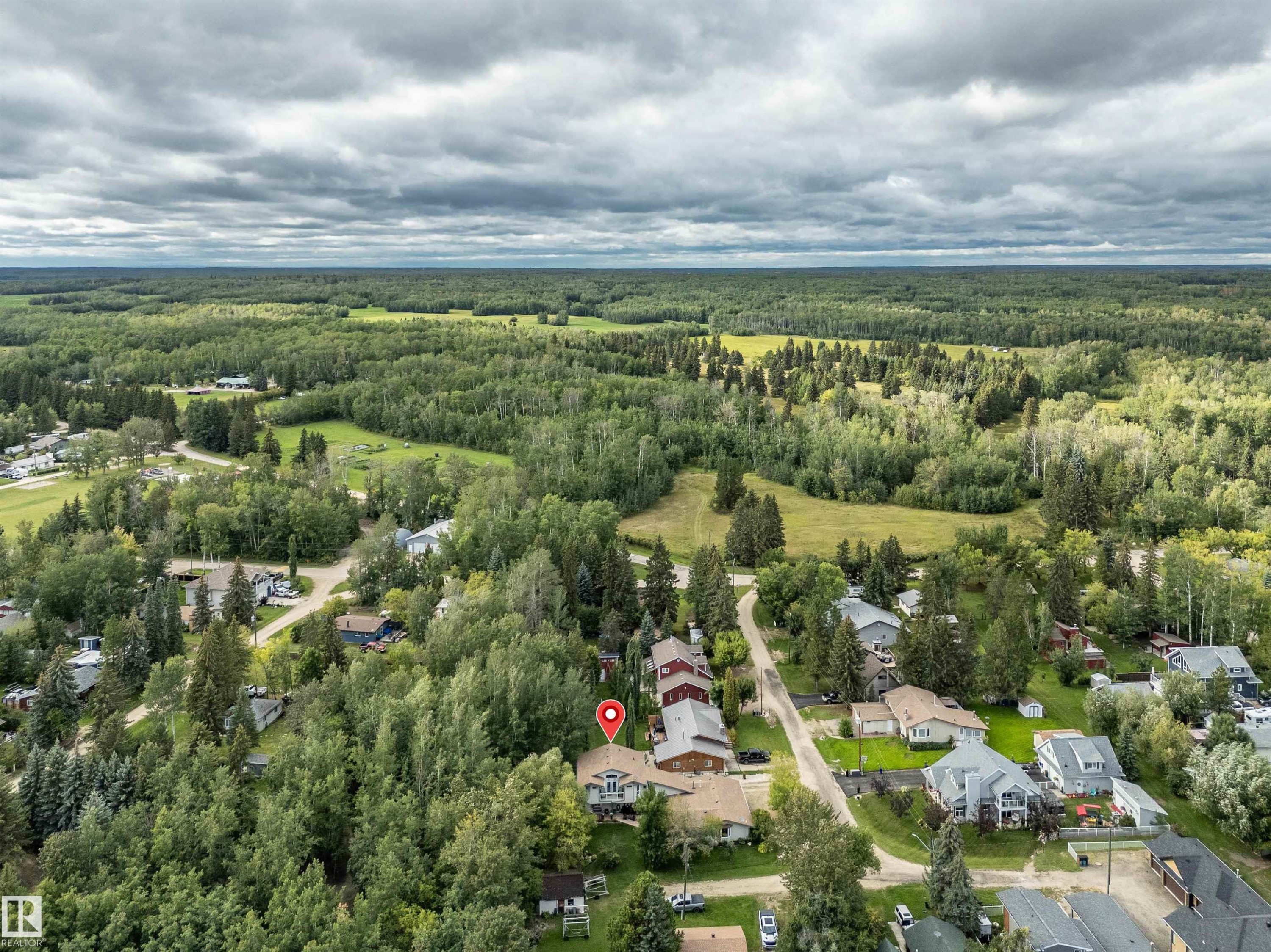 Aerial view of property and surrounding area featuring a heavily wooded area and nearby suburban area - 605 6St. Ross Haven, Rural Lac Ste. Anne County, AB - Outdoor With View