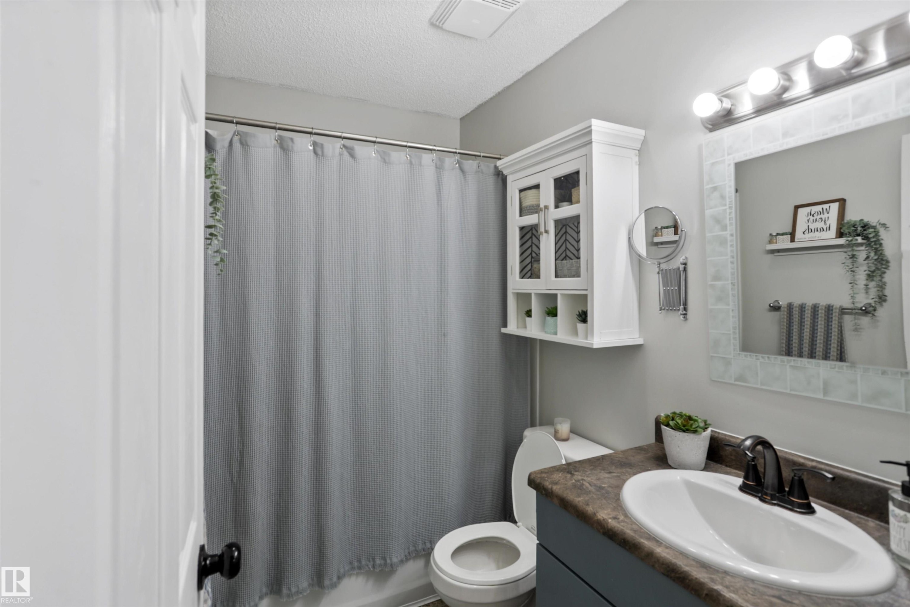 Bathroom with vanity, a textured ceiling, and shower / bath combo - 7 Chungo Drive, Devon, AB - Indoor Photo Showing Bathroom
