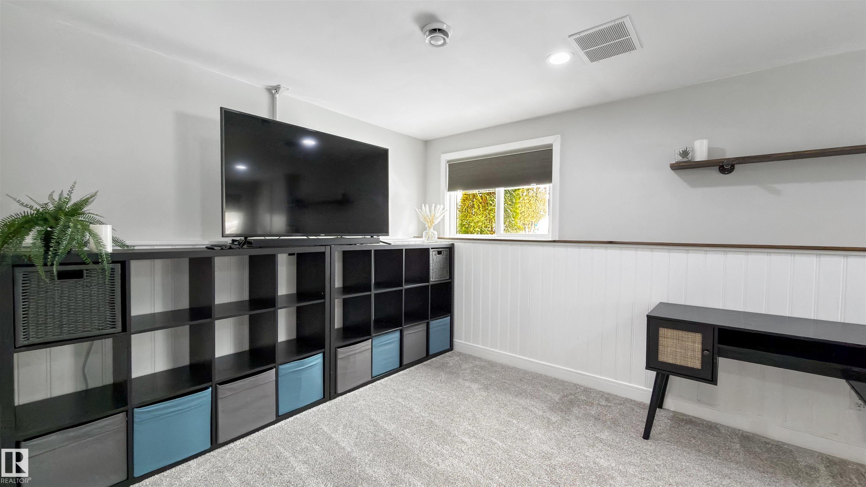 Rec room featuring light colored carpet and a wainscoted wall - 7 Chungo Drive, Devon, AB - Indoor Photo Showing Other Room