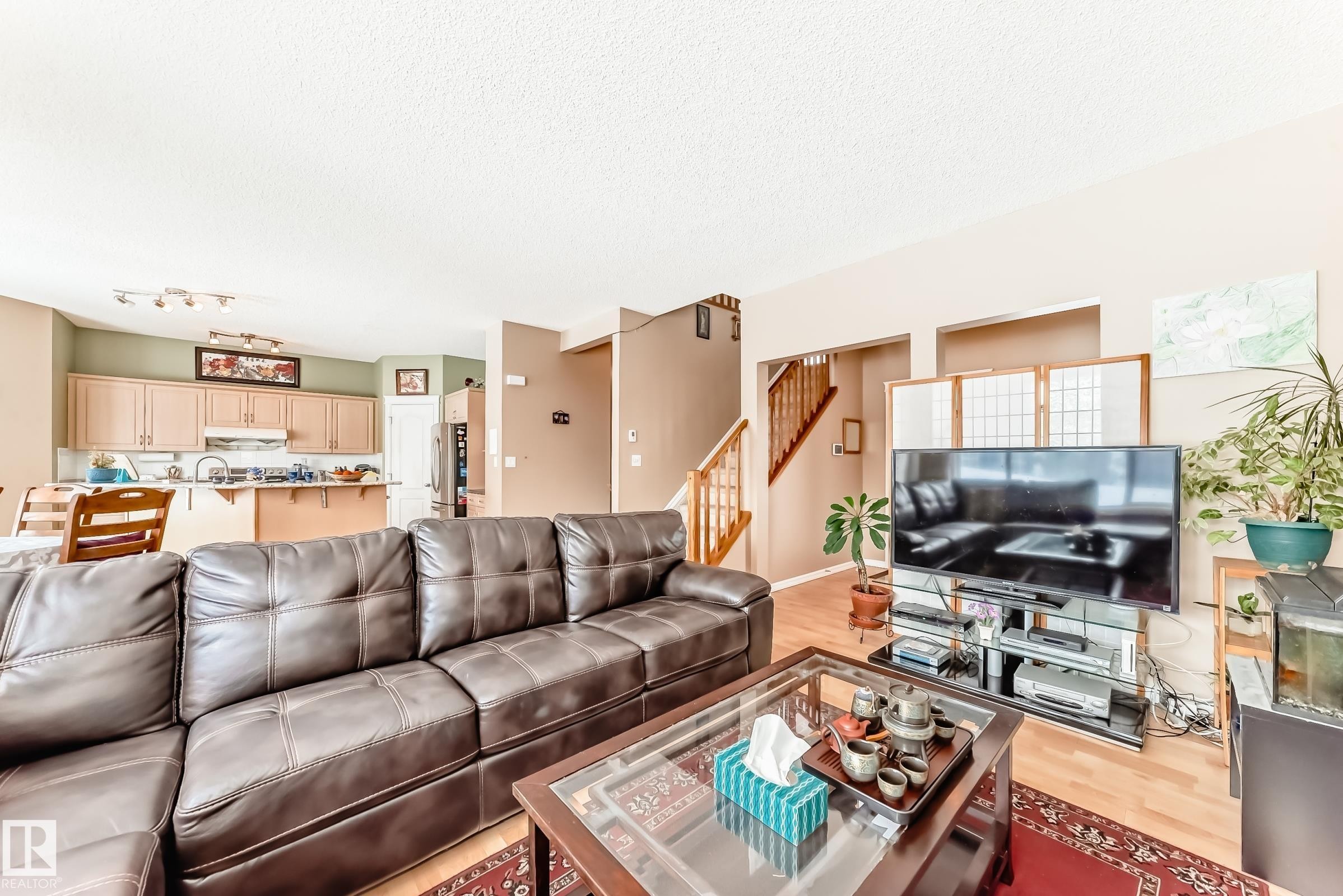 Living room featuring light wood finished floors and a textured ceiling - 4619 151 Avenue, Edmonton, AB - Indoor Photo Showing Living Room