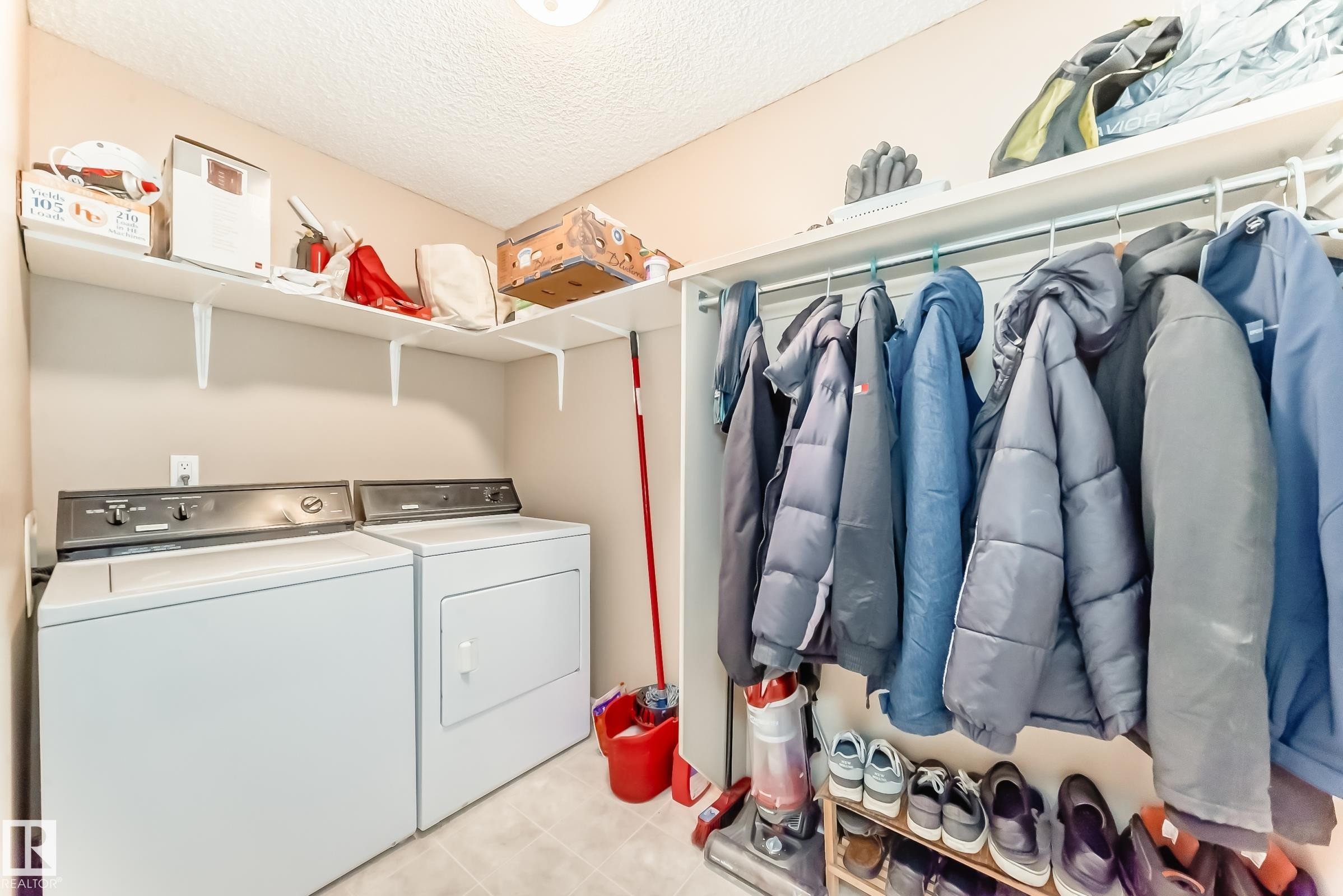 Laundry room with separate washer and dryer and a textured ceiling - 4619 151 Avenue, Edmonton, AB - Indoor With Storage