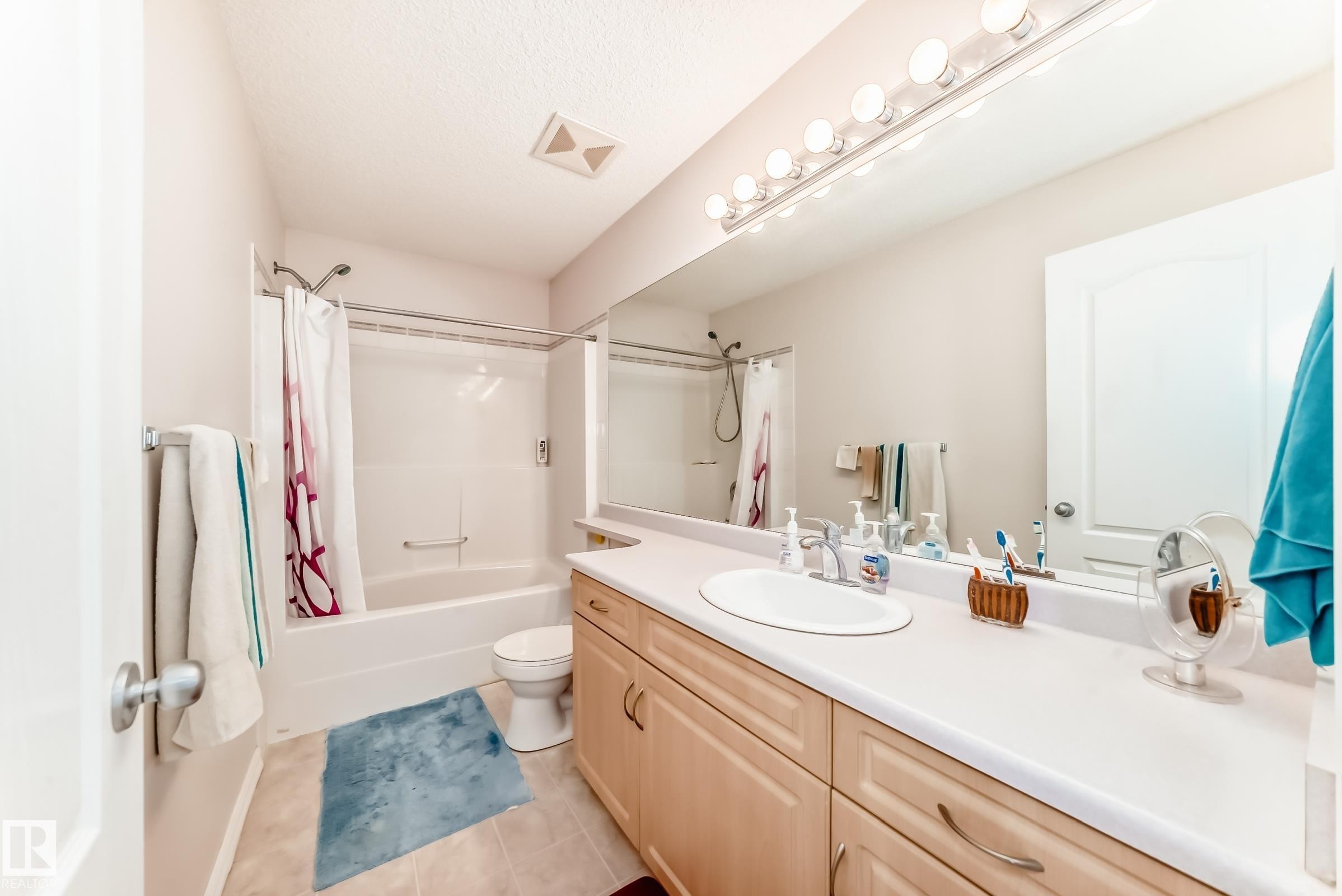 Full bathroom with vanity, shower / tub combo, and light tile patterned flooring - 4619 151 Avenue, Edmonton, AB - Indoor Photo Showing Bathroom