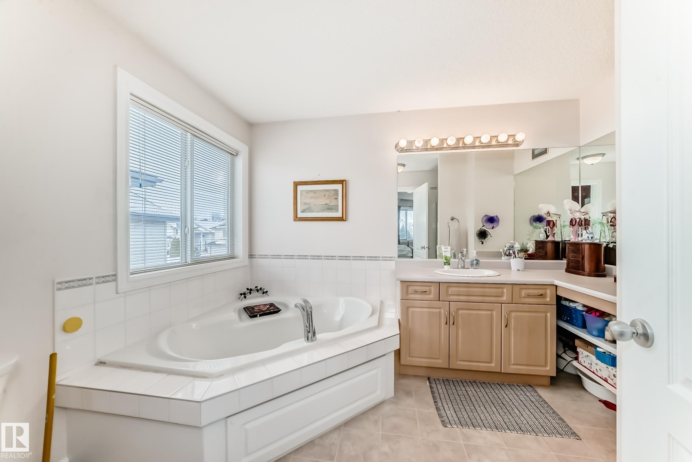 Bathroom with vanity, a garden tub, and light tile patterned floors - 4619 151 Avenue, Edmonton, AB - Indoor Photo Showing Bathroom