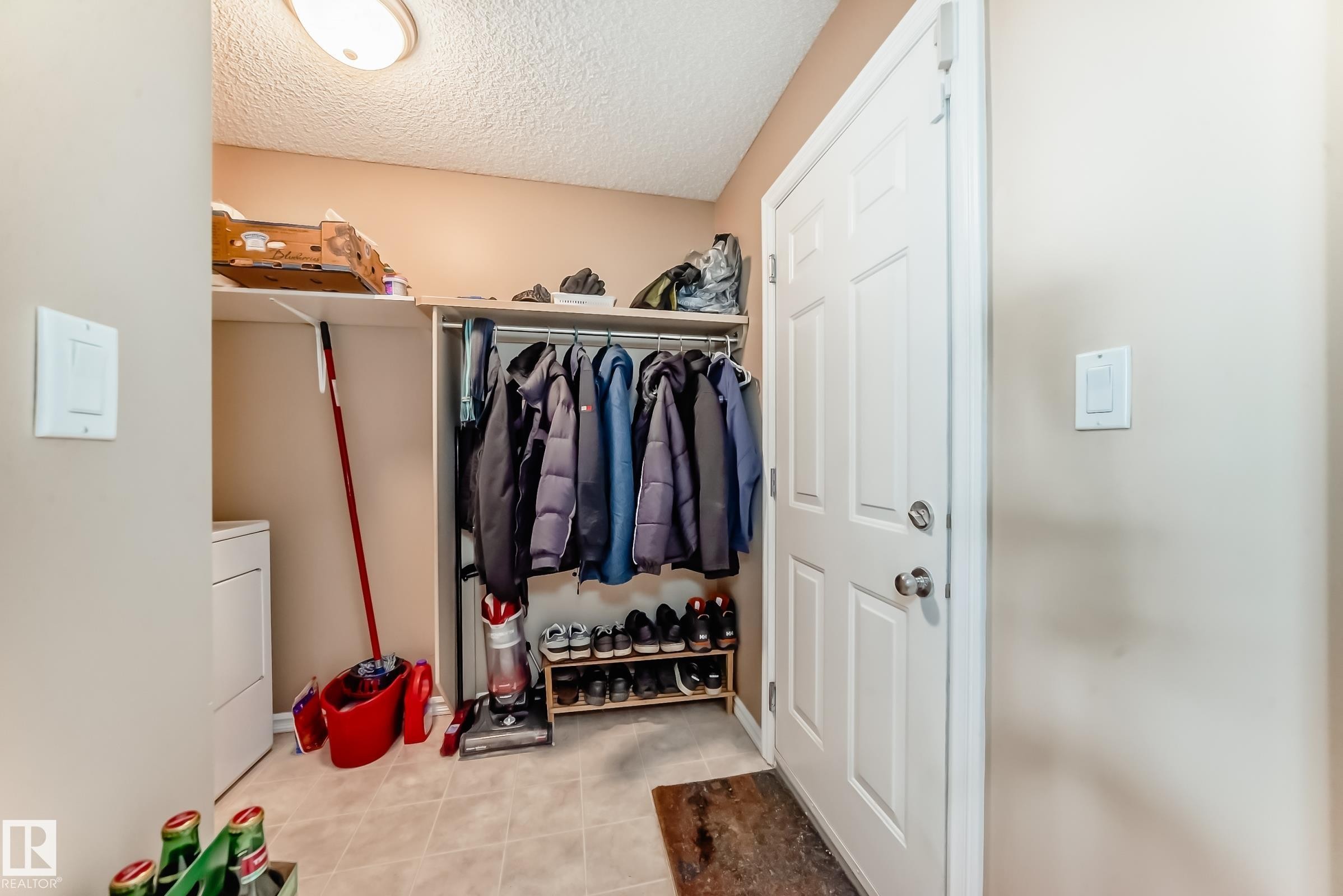 Interior space featuring washer / dryer and light tile patterned floors - 4619 151 Avenue, Edmonton, AB - Indoor With Storage