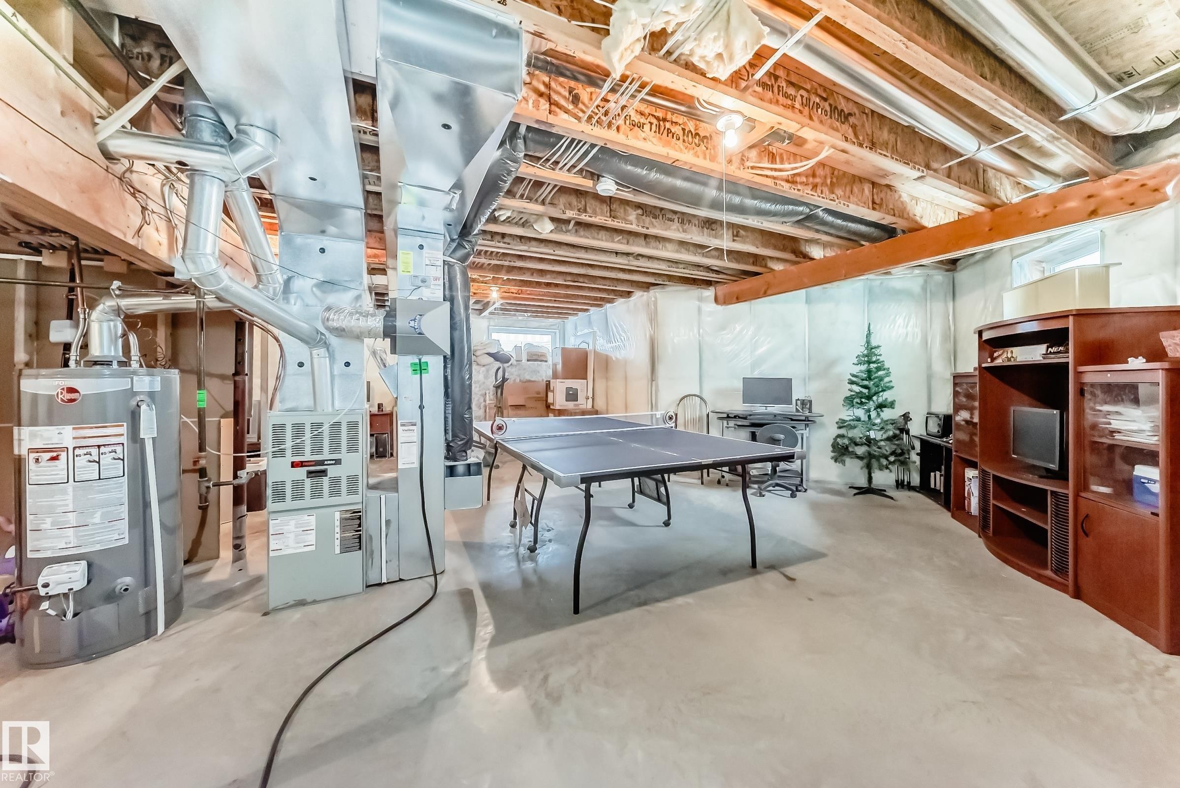 Unfinished below grade area with water heater - 4619 151 Avenue, Edmonton, AB - Indoor Photo Showing Basement